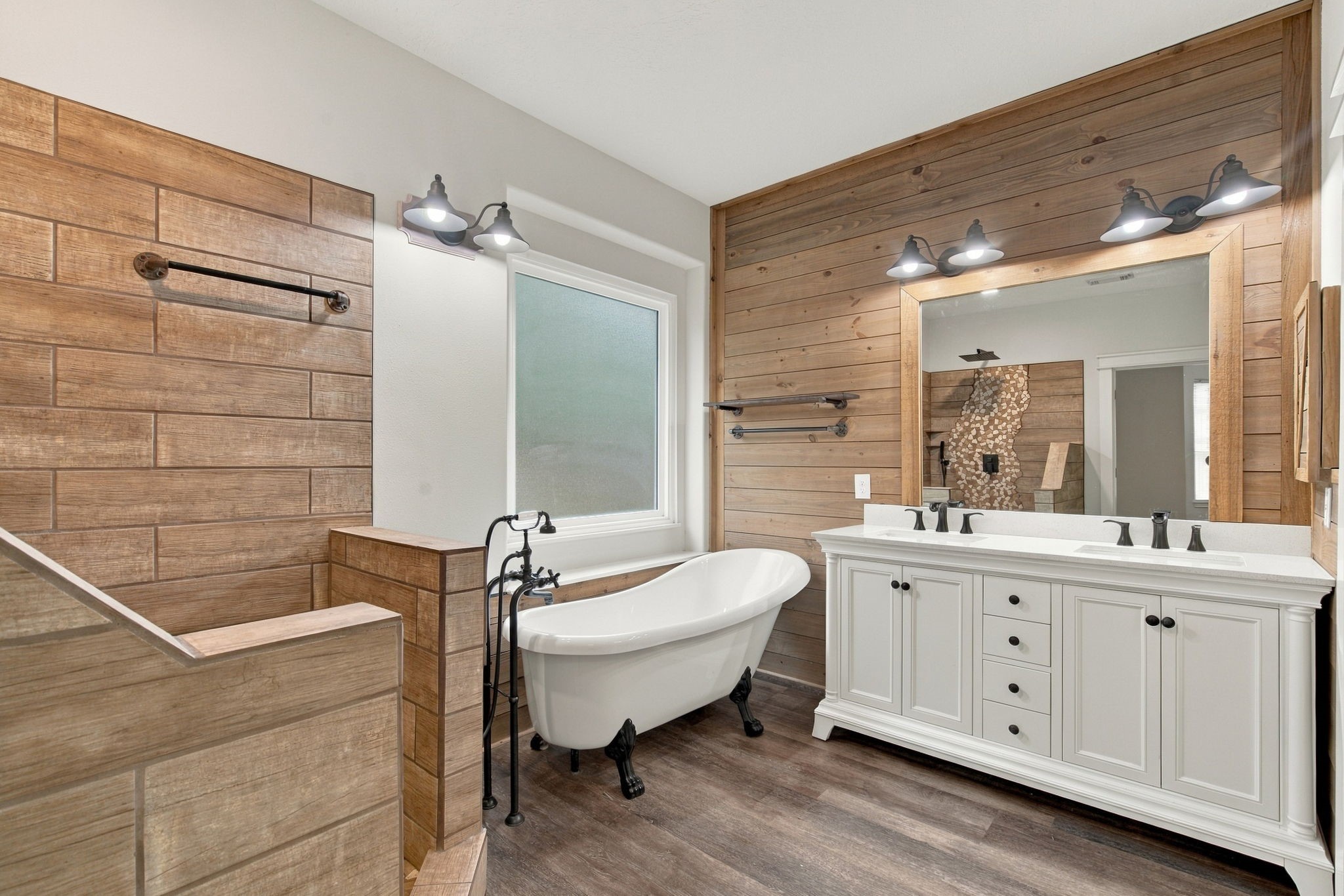 Stunning primary bathroom with dual sinks, a soaking tub, and dual walk-in closets.