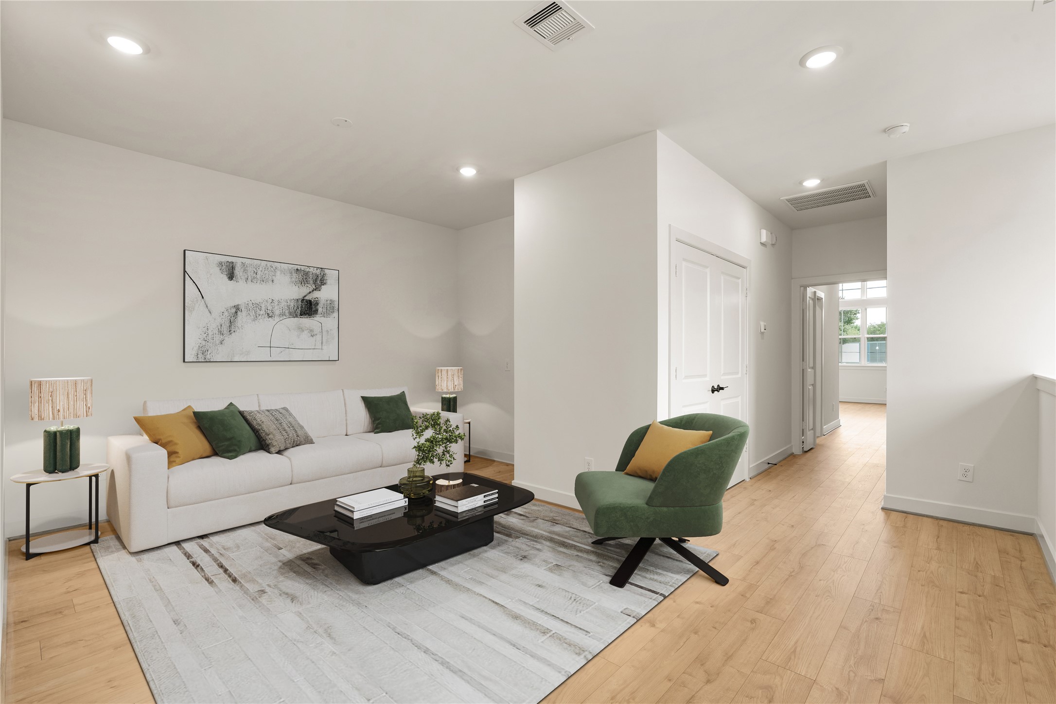 Versatile upper-level loft  neutral sofa, modern accent chair, plush patterned area rug, and smooth wide-plank floors creating a cozy secondary living space.