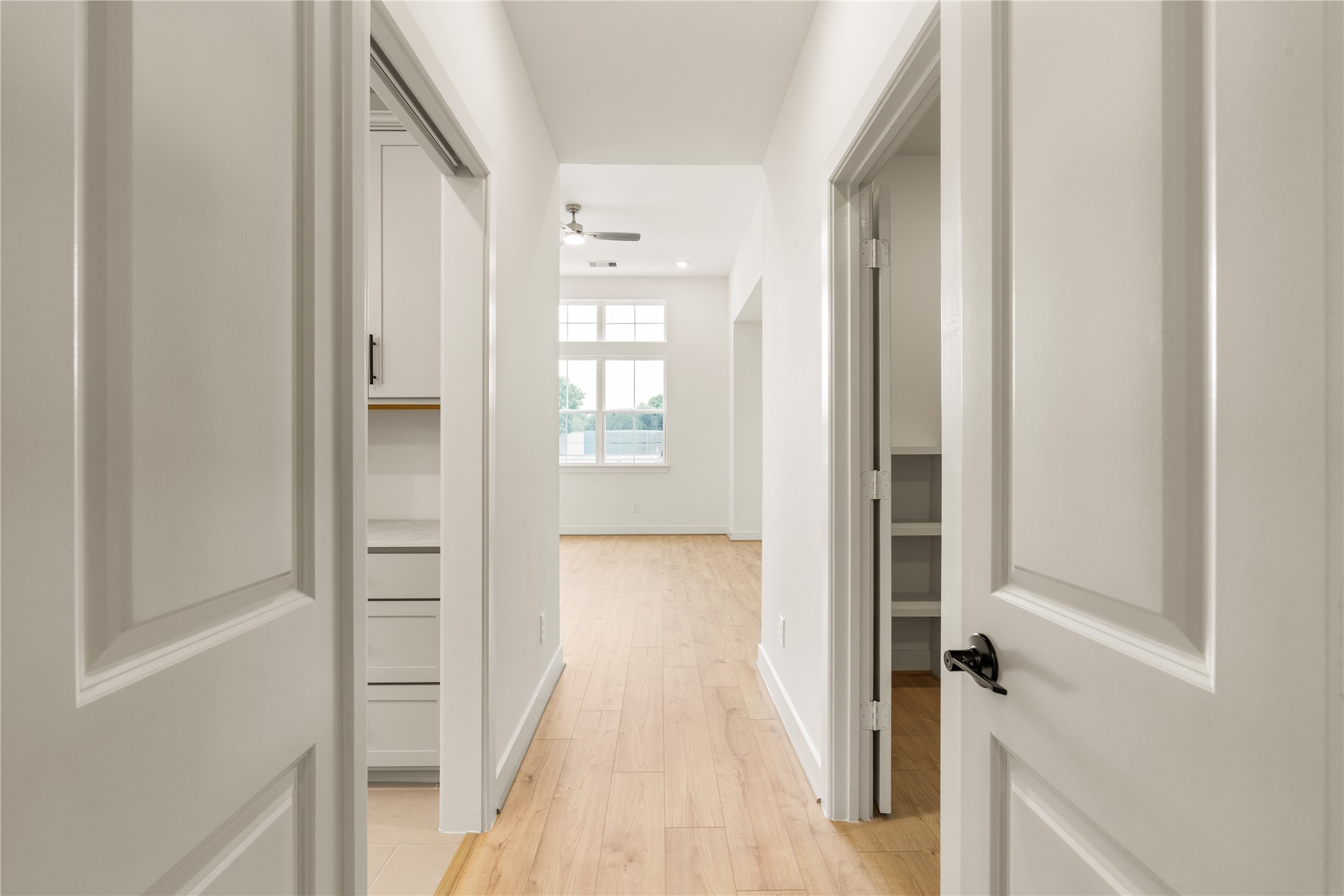 Primary suite private hallway  direct door access connecting the bedroom suite, laundry area, and walk-in closet.