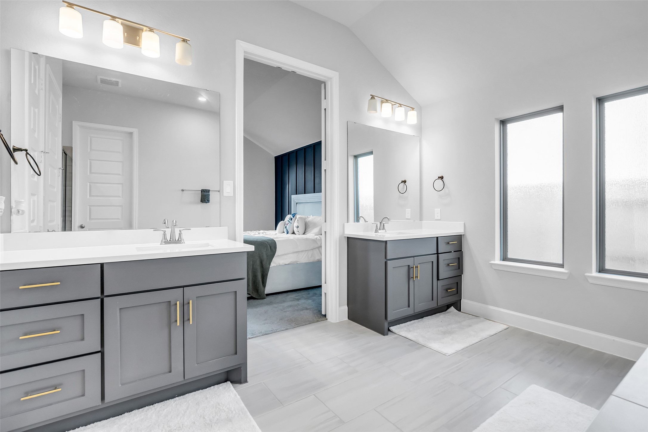 Get Prepared In Style w/ Your Dual Vanities, Sleek Gray Cabinetry, & Modern Light Fixtures. Abundant Natural Light Streams Through Frosted Windows, Creating A Serene & Inviting Atmosphere.