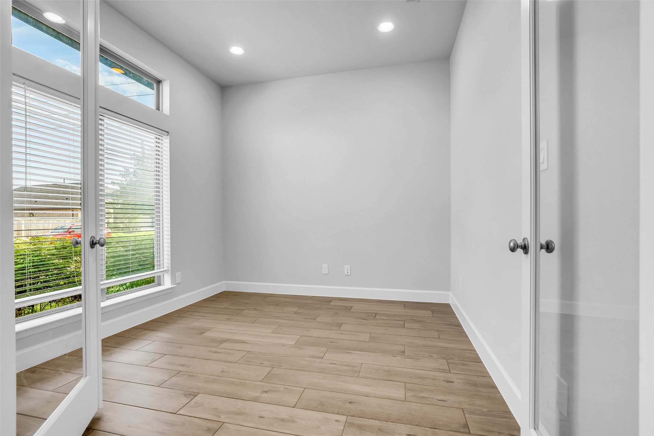 Your Flex Space Is Bright & Inviting w/ Large Windows, Stylish Wood-look Tile, & Elegant Double Doors, Perfect For A Home Office, Gameroom, or Cozy Retreat.
