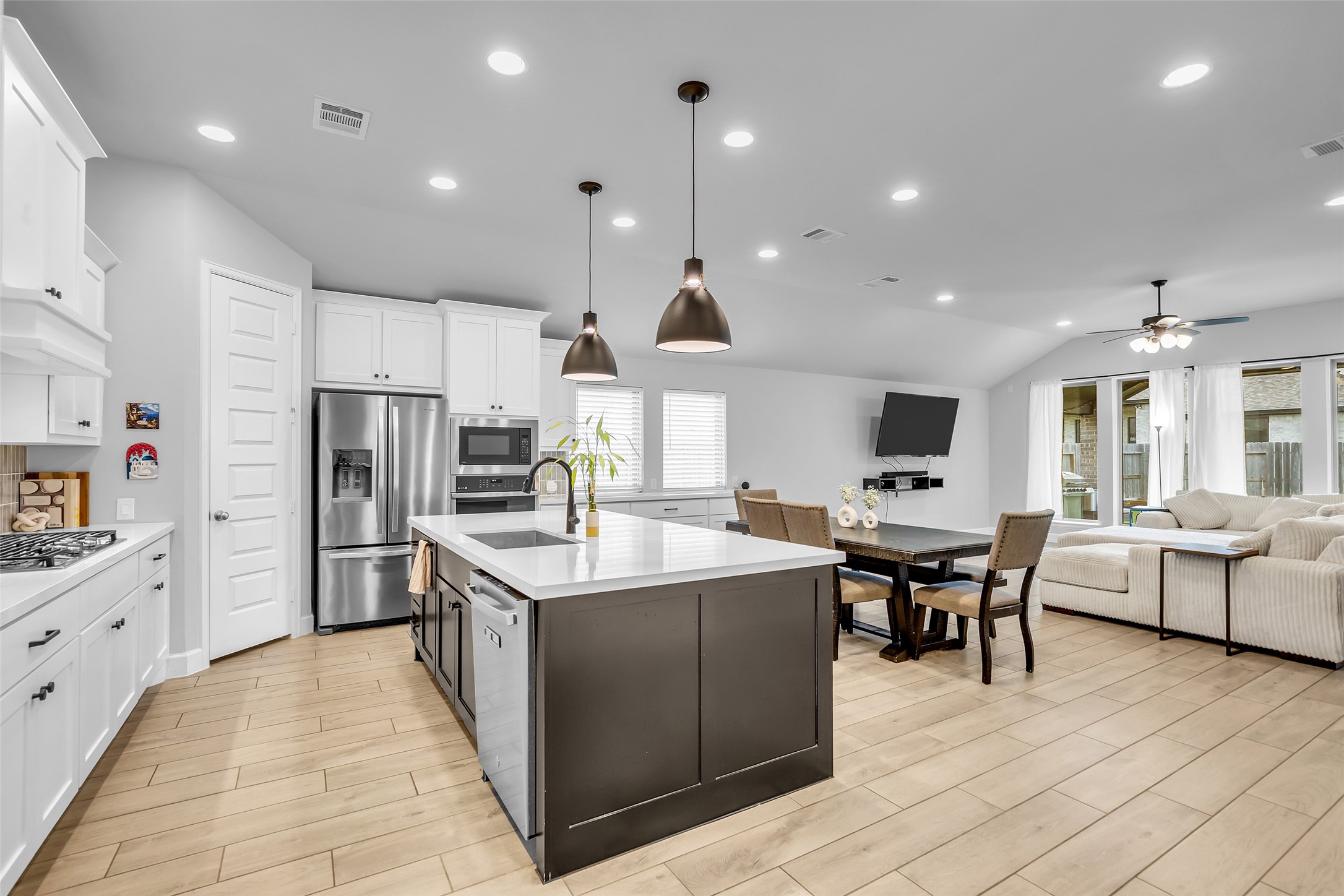 Your Modern, Open-Concept Kitchen & Living Area Features  Spacious Island w/ Designer Pendant Lighting, Stainless Steel Appliances, & A Cozy Dining Nook, Seamlessly Flowing Into A Bright, Inviting Living Space w/ Large Windows.