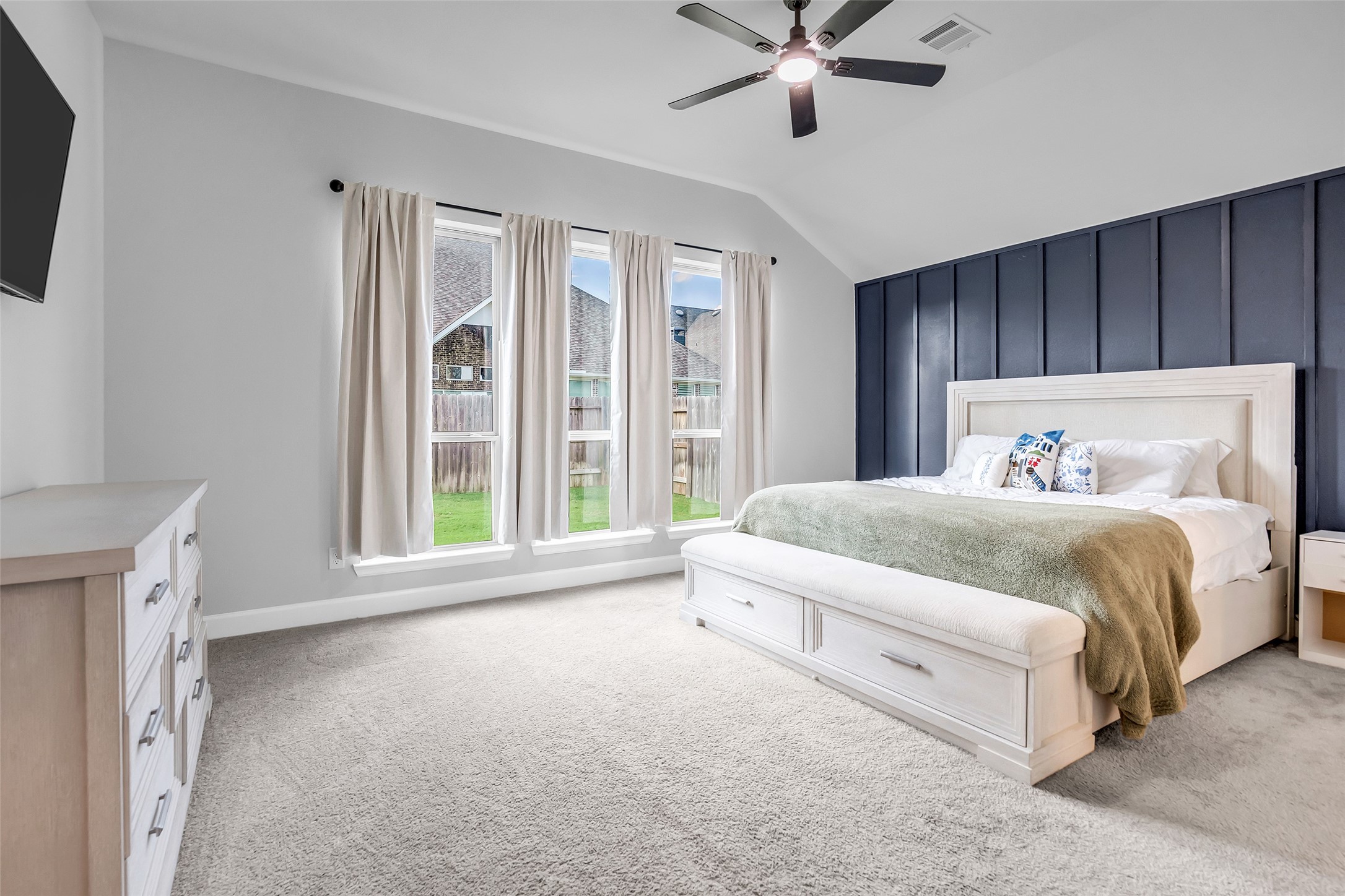 Your Primary Retreat Featuring Tall Ceilings, Elegant Accent Wall, & Large Windows Providing An Abundance of Natural Light.
