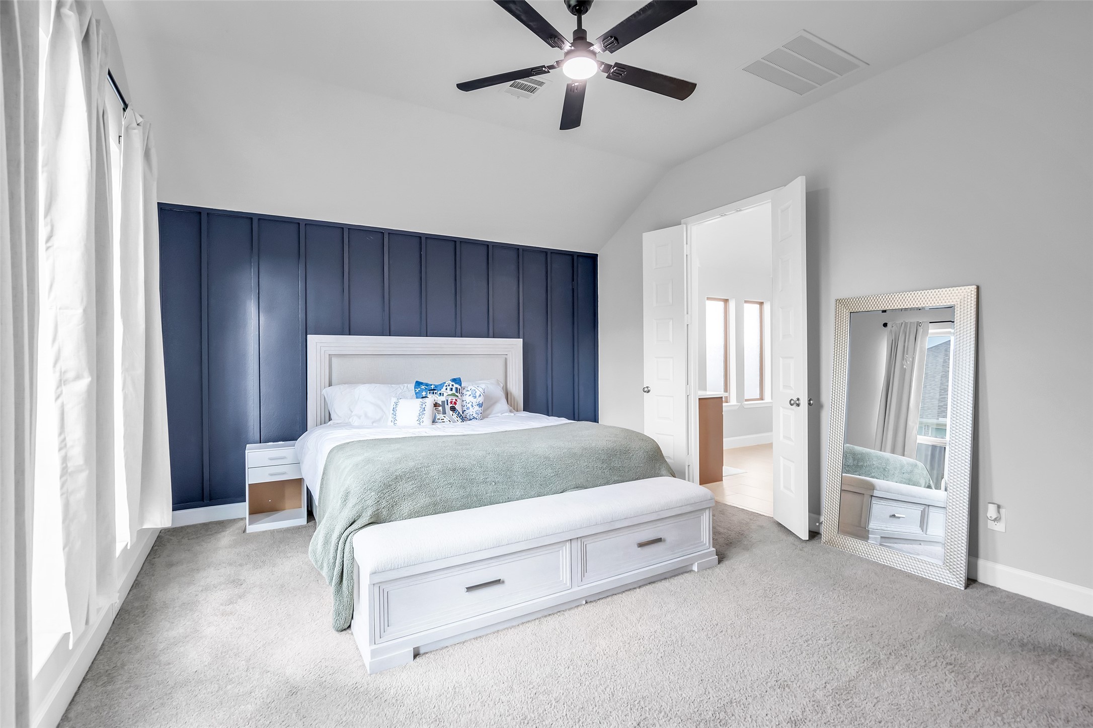 Your Spacious Bedroom Features 8' Doors, Plush Carpeting, & Ceiling Fan, & Lovely Double Doors Leading to Your Primary Bath.