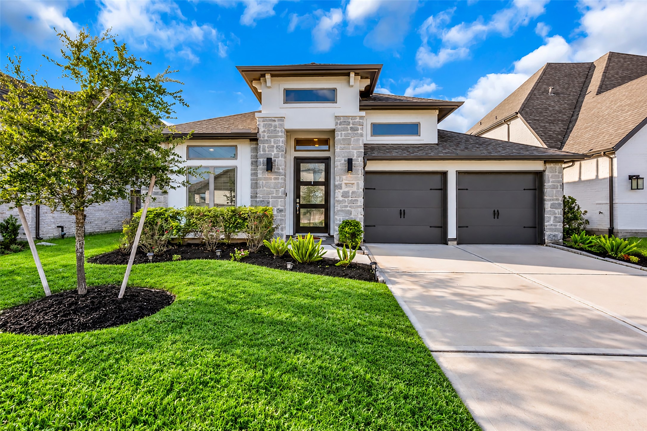 Welcome To 30047 Golf Finch Place! Your Modern Perry Home Features Elegant Stone Faade, Elegant Design, And A Manicured Front Lawn, & Spacious Two-car Garage.