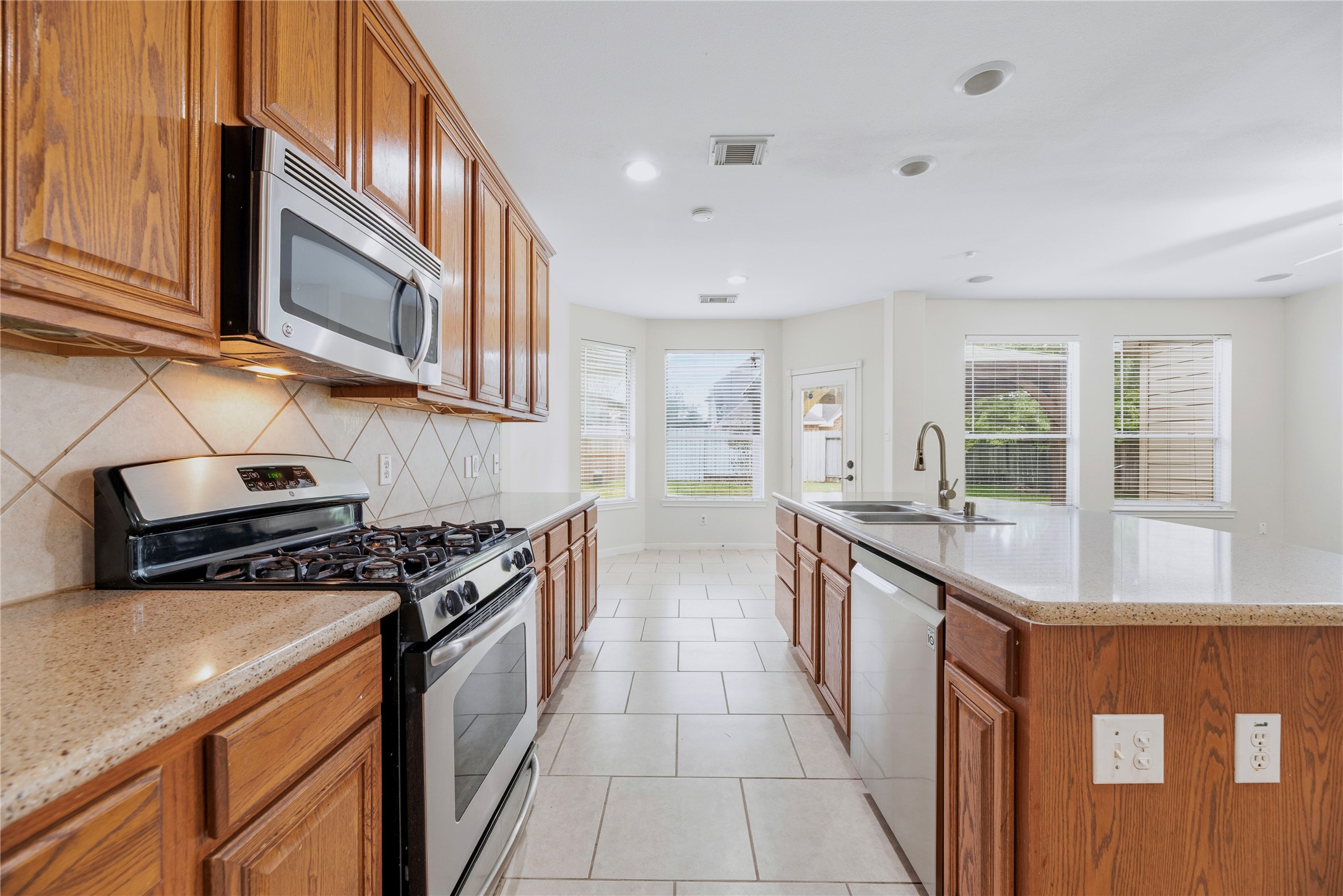Cabinets along the cooking wall and a central island provide separate places for meal preparation and storage, with the breakfast area just beyond.