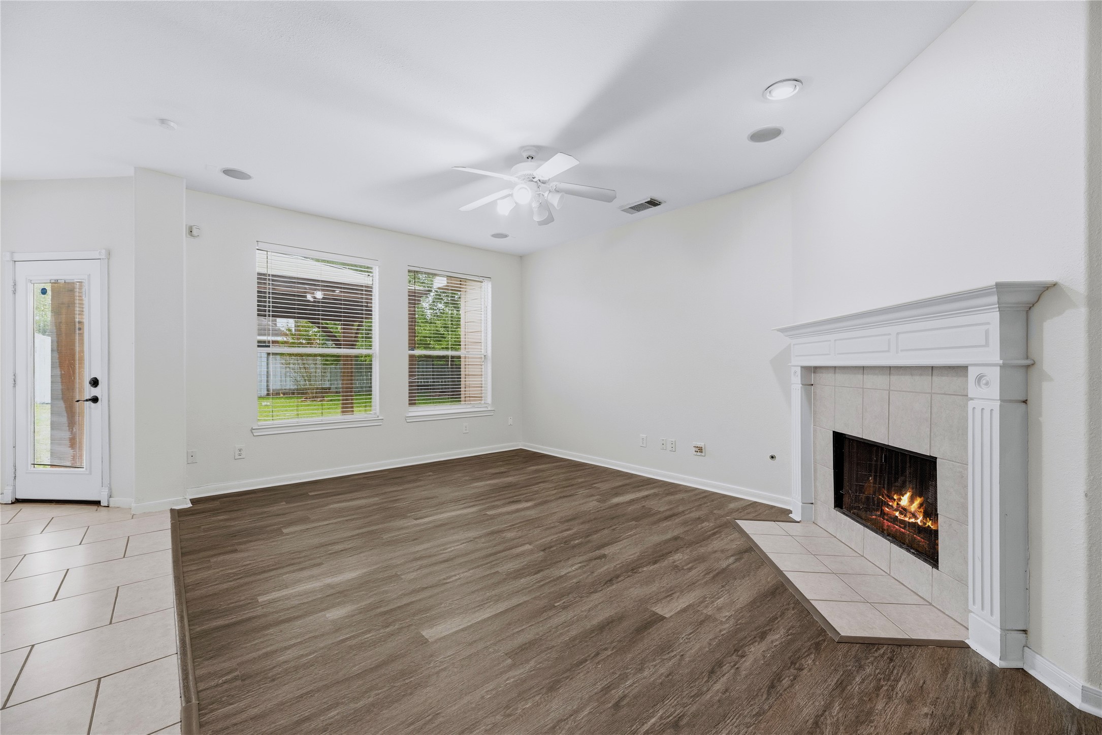 The fireplace anchors the family room, while rear windows and the nearby backyard door connect the indoor living space with the outdoors.