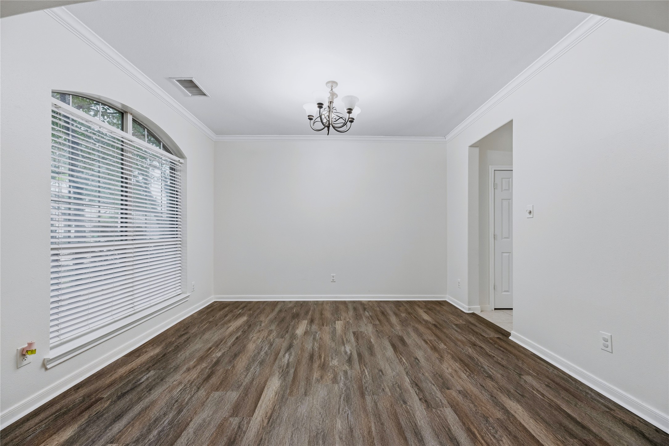 A large arched window and chandelier define the separate dining room, giving you a dedicated place for meals or flexibility for your own setup.