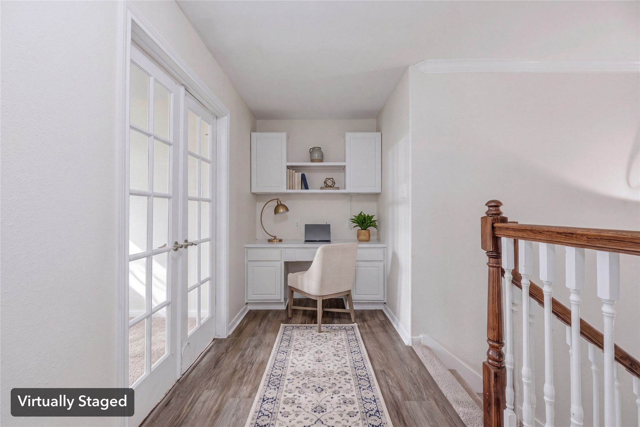 Virtually staged to illustrate the upstairs desk nook beside the French-door room. Furniture, decor and center shelf shown are digital.