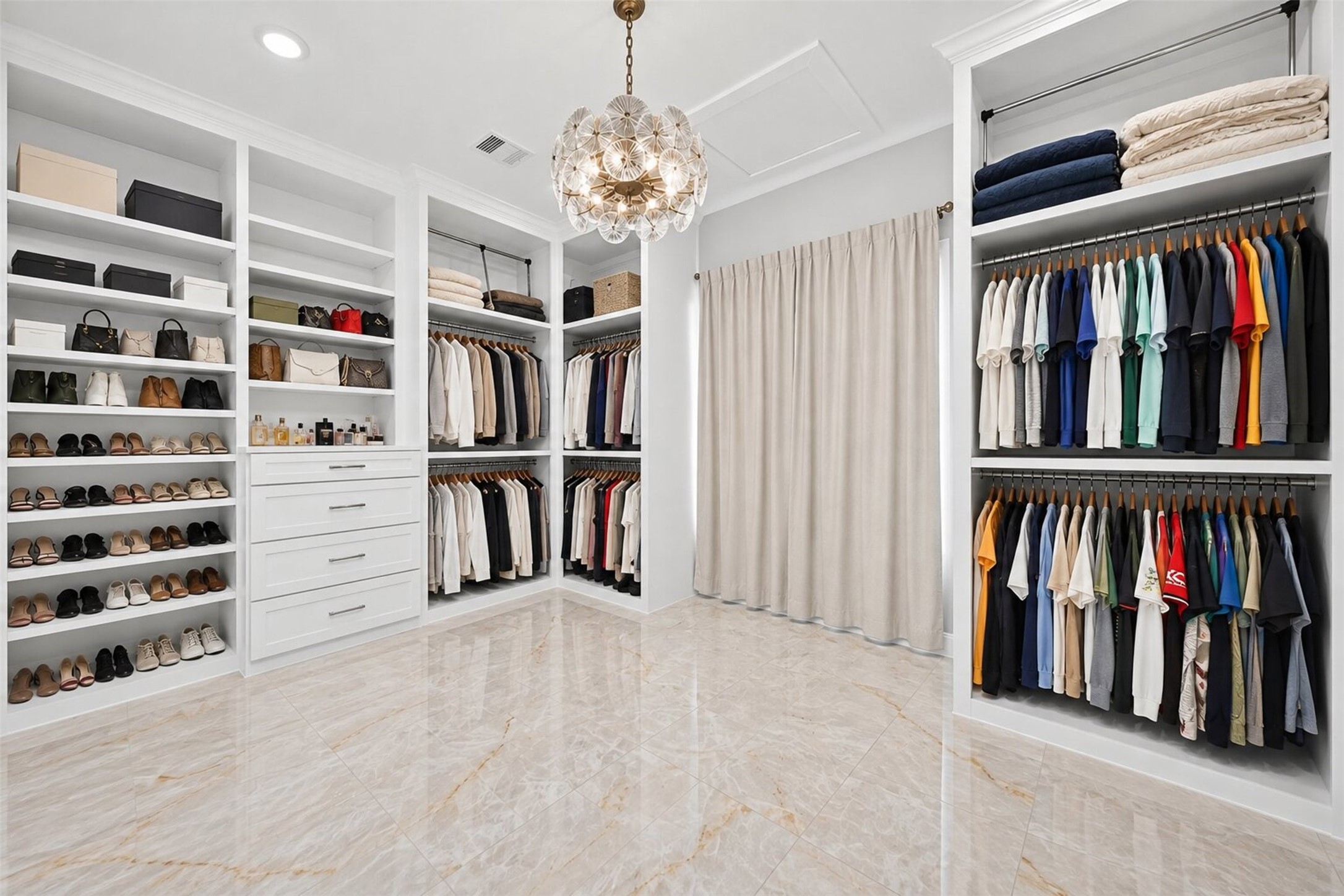 Built-in shelves, drawers, and double hanging rods provide dedicated storage throughout the primary closet.