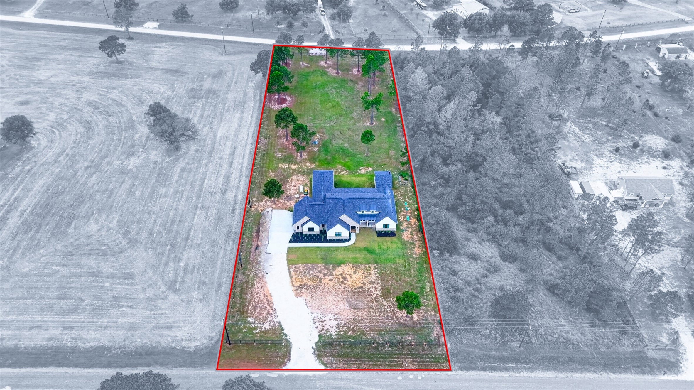 An aerial view highlights the home, driveway, and open grounds within the red-outlined property boundary.