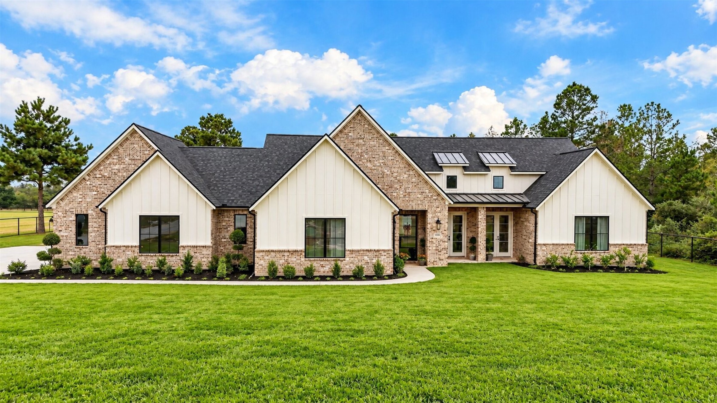 Set beneath a front gable, the recessed entry is framed by brick and light siding, with a walkway leading visitors to the door.