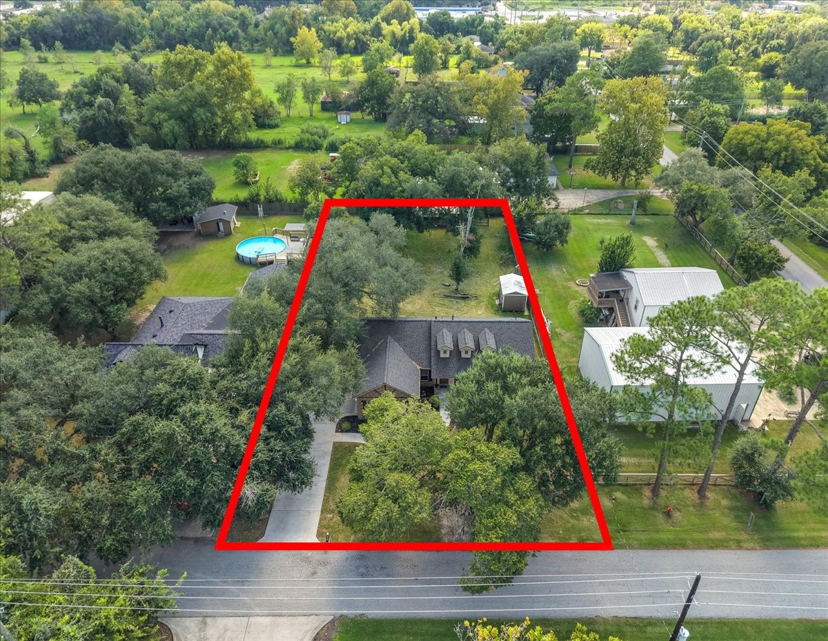 This bird's-eye view captures the full scope of the property, half an acre of shaded, usable yard space stretching from the front drive back through mature trees to the rear grounds. Plenty of room to spread out, garden, or add your own outdoor amenities.