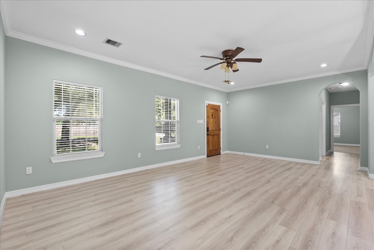 Vaulted transitions in the ceiling, a second ceiling fan, and continuous plank flooring tie the whole space together.