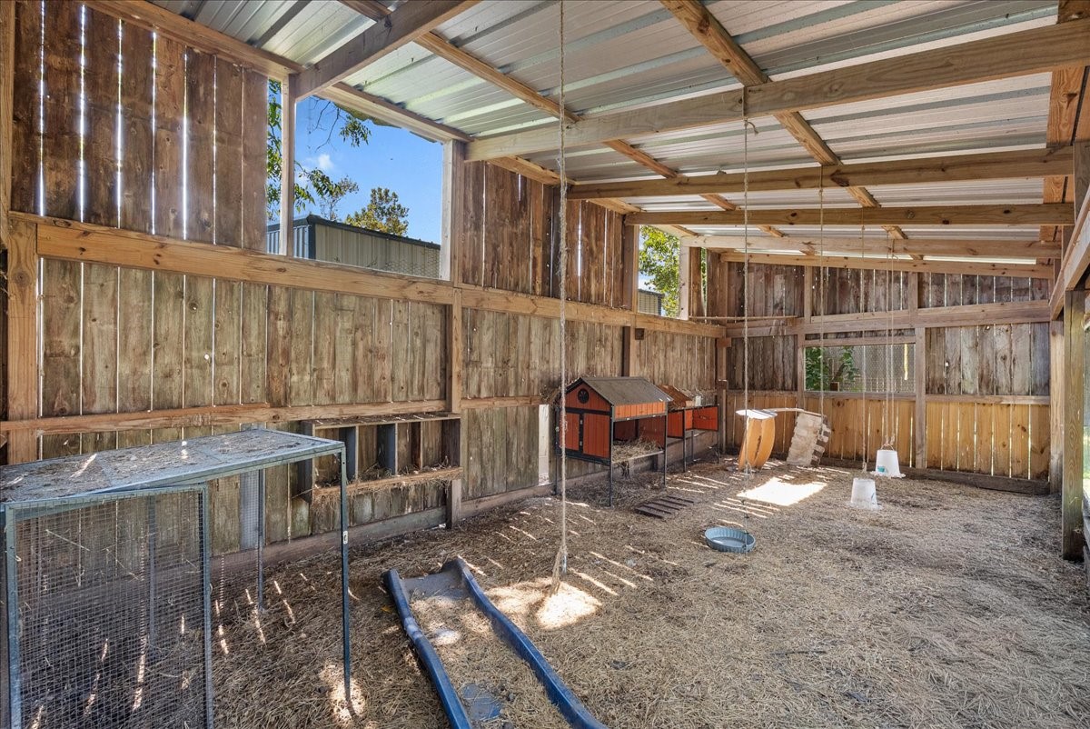 Built out with wood-plank walls, a durable metal roof, and wire-enclosed sections for secure housing, this spacious coop includes built-in nesting boxes and multiple roosting areas, a true turnkey setup for chickens or other small livestock.