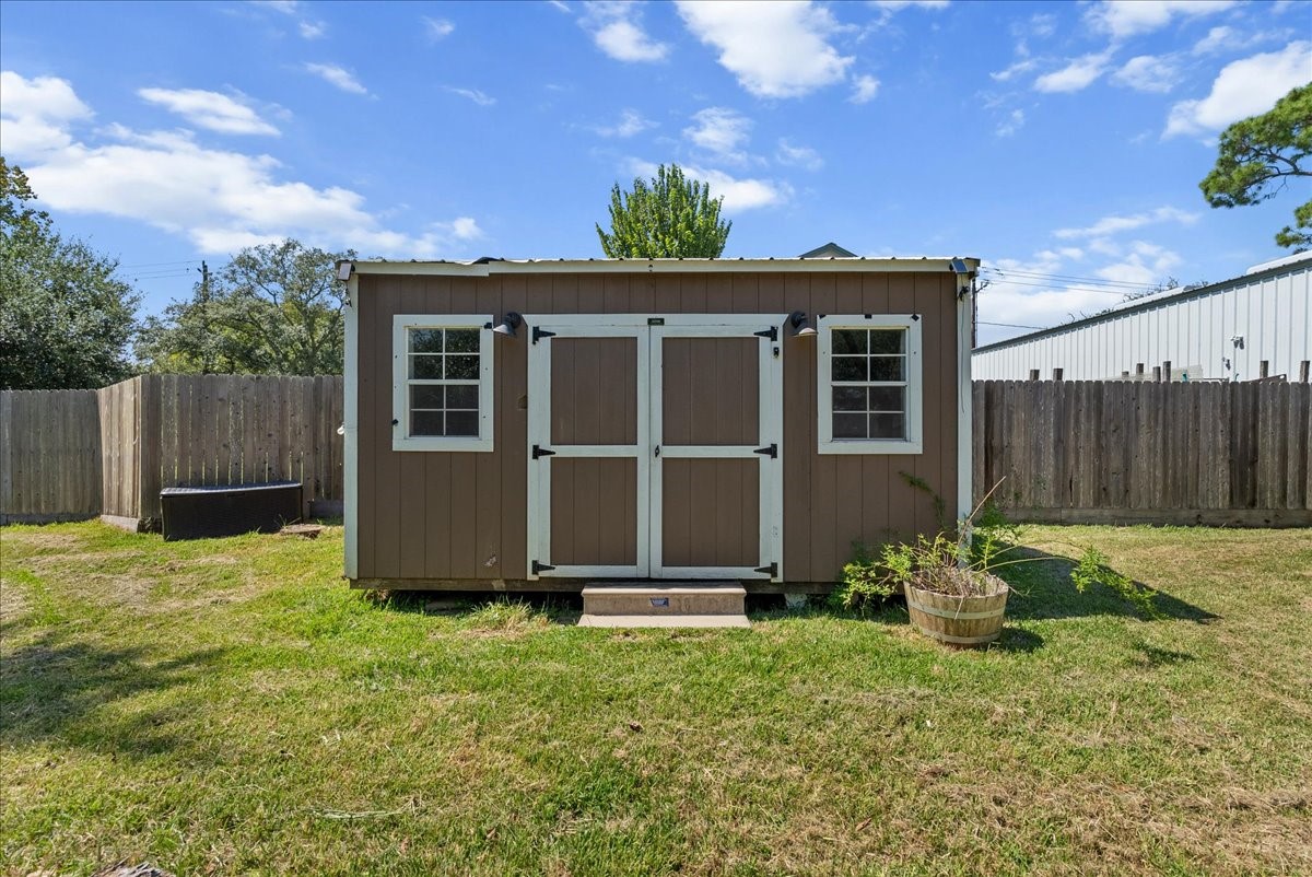 The hardwired storage building offers double doors, windows on either side for natural light, and wiring already in place, ready to be a workshop, hobby space, or private retreat.