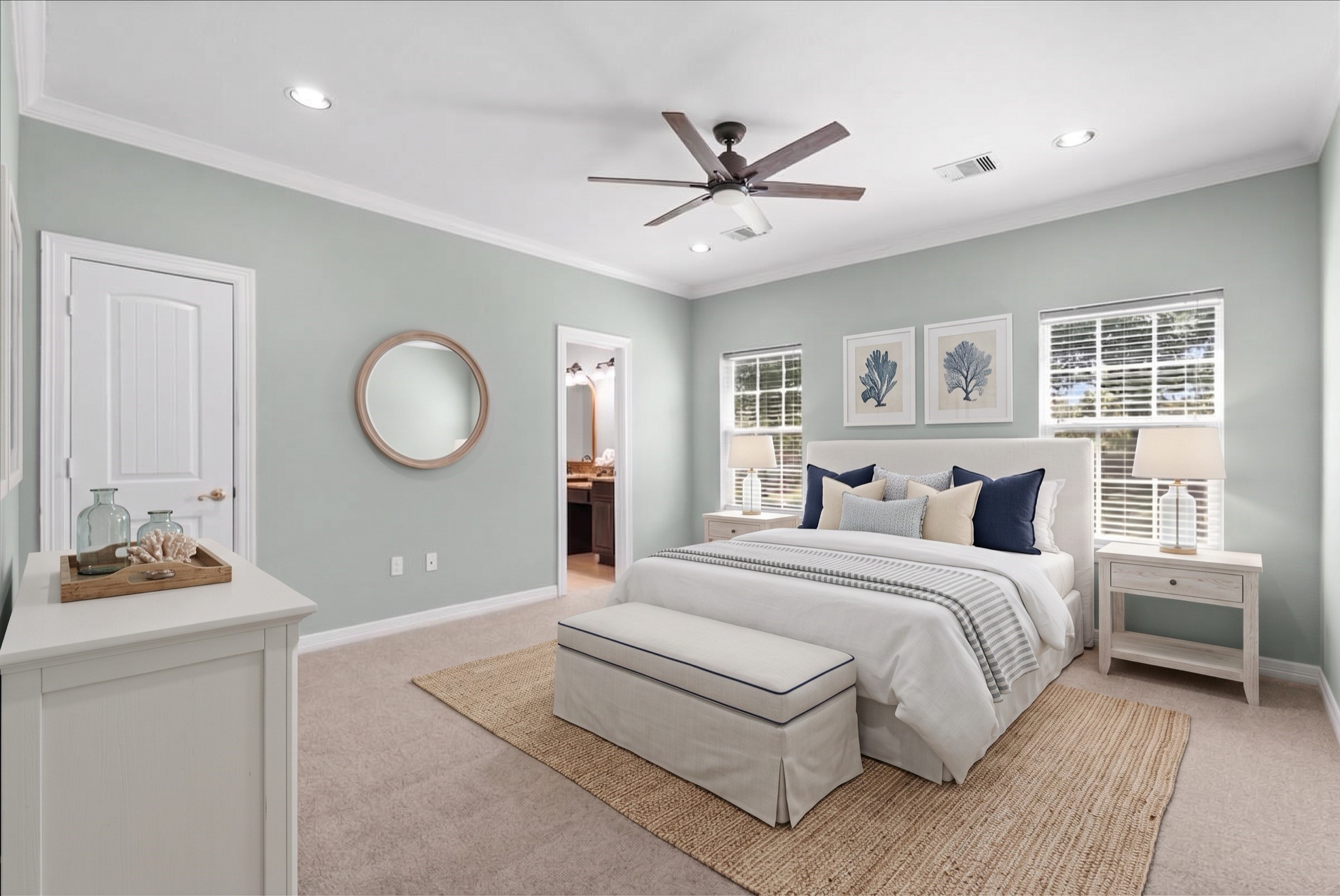 The primary suite offers new carpet, crown molding, and a ceiling fan, with dual windows filling the room with natural light. An en-suite bathroom connects directly, and a walk-in closet completes the space.