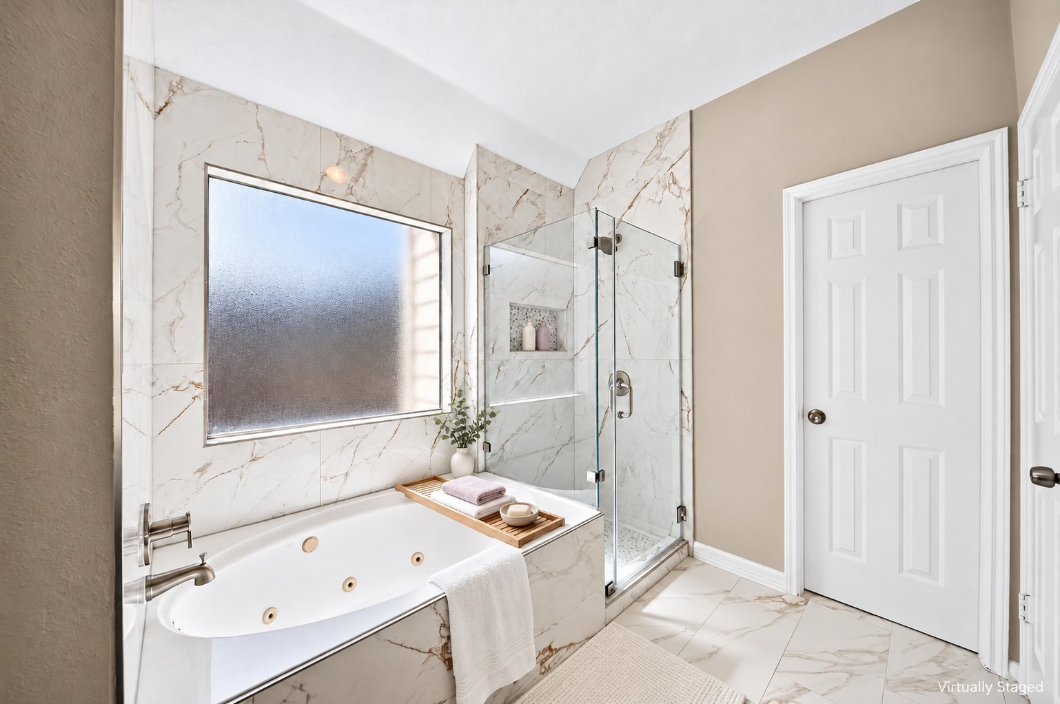 Primary Bathroom  Tub & Shower: The beautifully remodeled primary bathroom features a jetted soaking tub, frameless glass shower, recessed niche and a large privacy window.
