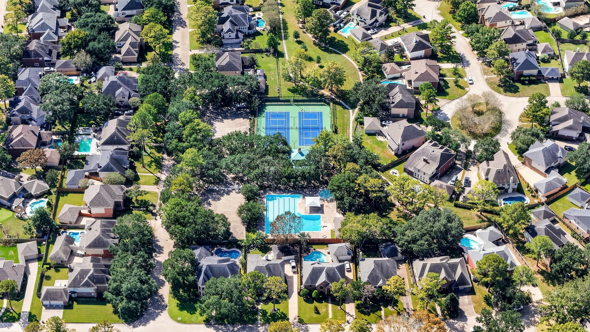 Aerial View  Nearby Recreational Amenities

Aerial view highlights nearby recreational amenities, including a swimming pool, tennis courts and landscaped green spaces surrounded by mature trees.