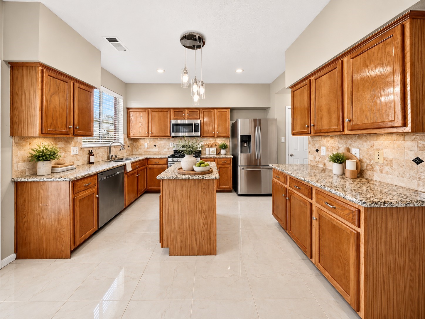 Kitchen  Full View - 
Spacious kitchen featuring rich wood cabinetry, granite countertops, stainless steel appliances, a center island and stylish pendant lighting, offering generous storage and preparation space.