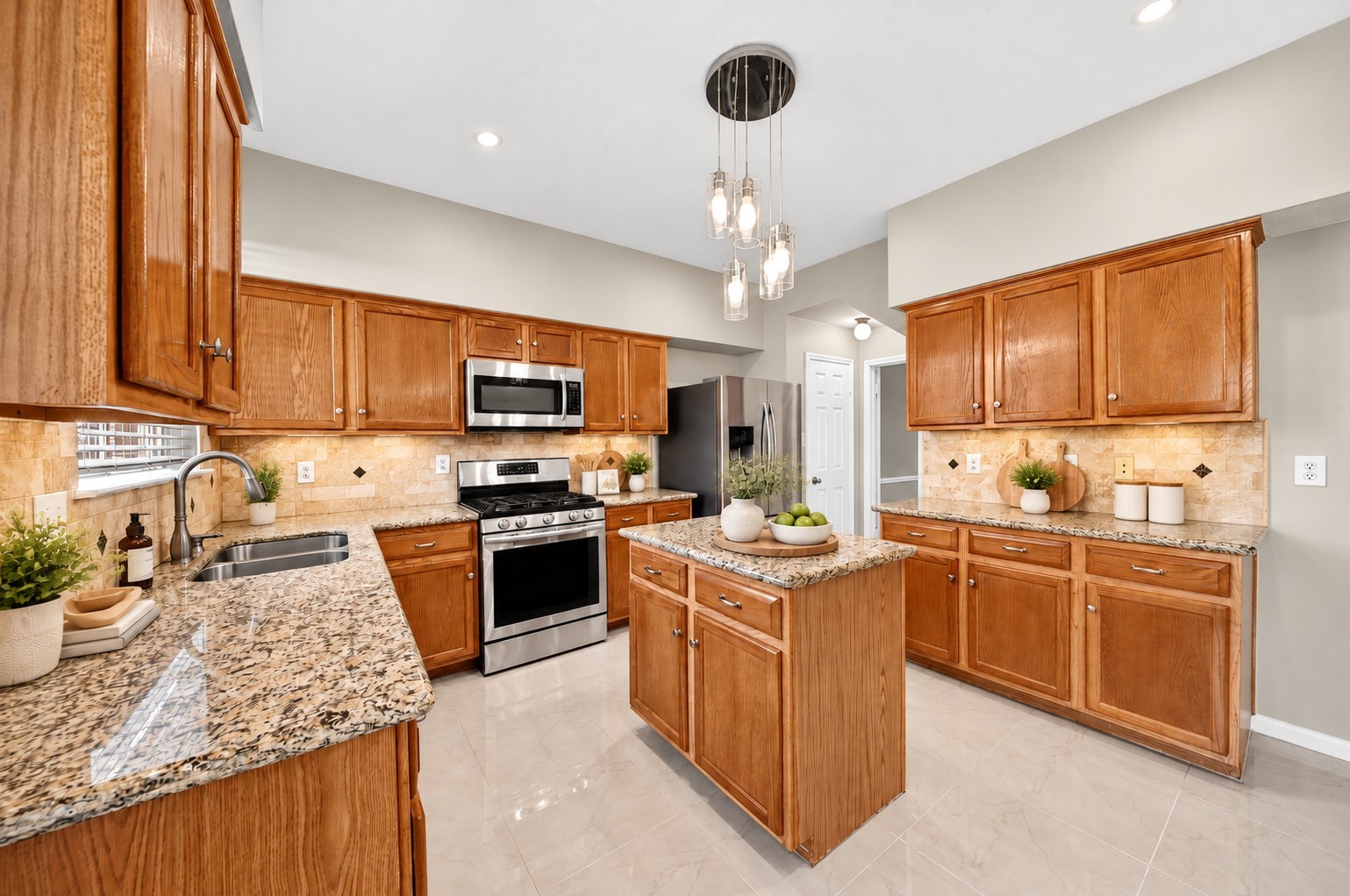 Kitchen  Additional View - Enjoy generous countertop space, abundant cabinetry and a functional center island in this spacious kitchen, where warm finishes and polished tile flooring create a timeless appeal.