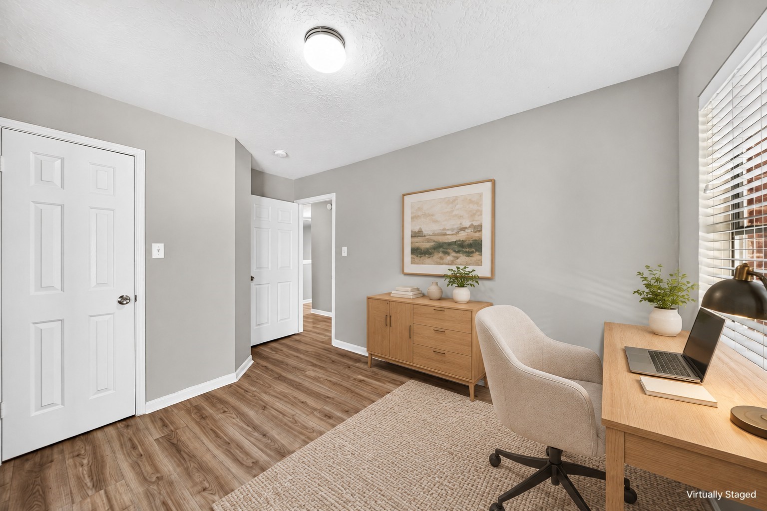 Office / Flex Room: Versatile room staged as a home office, featuring attractive wood-look flooring, closet storage and natural light for a comfortable workspace.