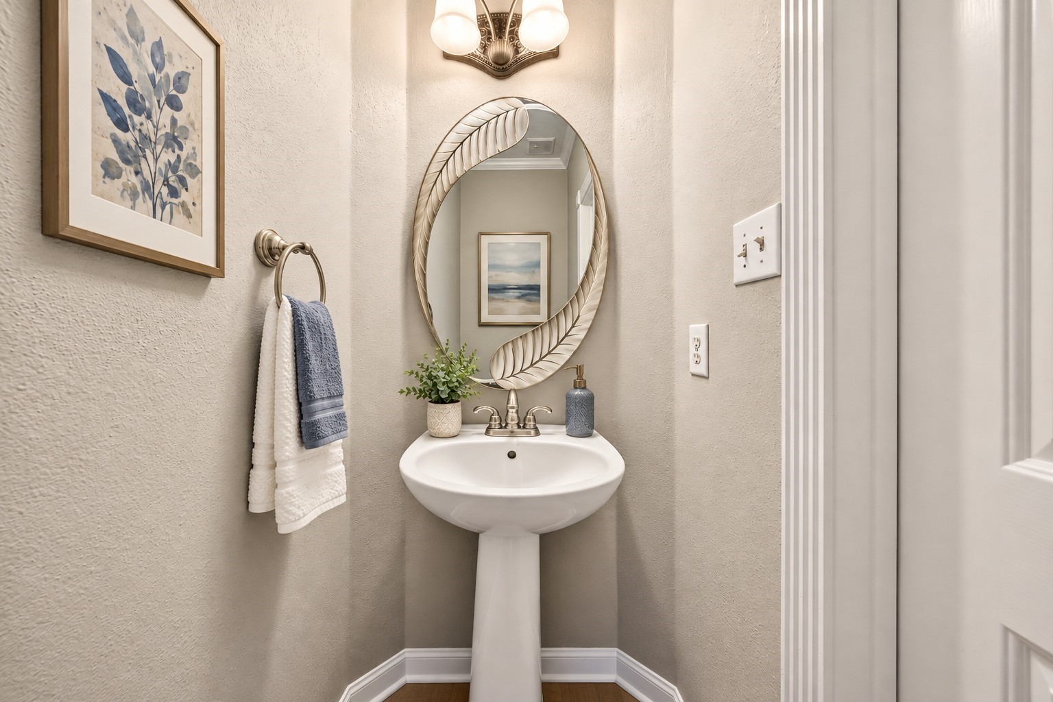 Half Bathroom: Conveniently located powder room features a classic pedestal sink, neutral finishes and a clean, understated design.