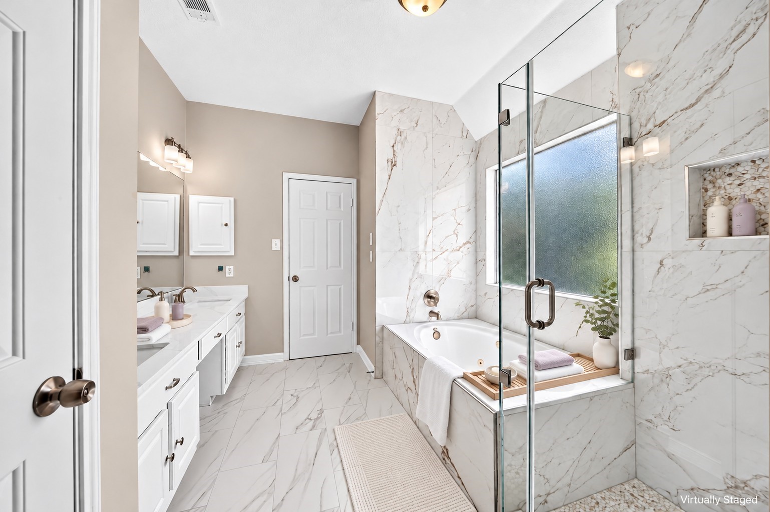 Primary Bathroom: Experience spa-inspired comfort with beautiful marble-look finishes, an enclosed glass shower, jetted soaking tub and spacious vanity area.