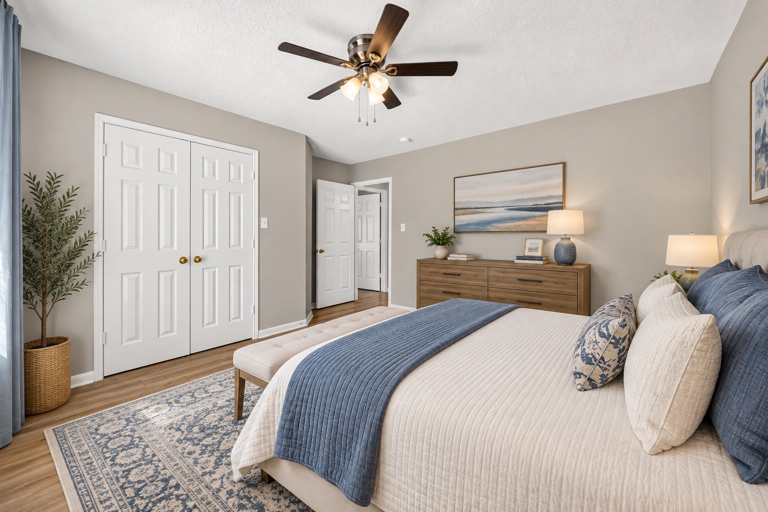 Secondary Bedroom: Spacious secondary bedroom showcasing beautiful wood-look flooring, neutral tones and double-door closet storage for everyday convenience.