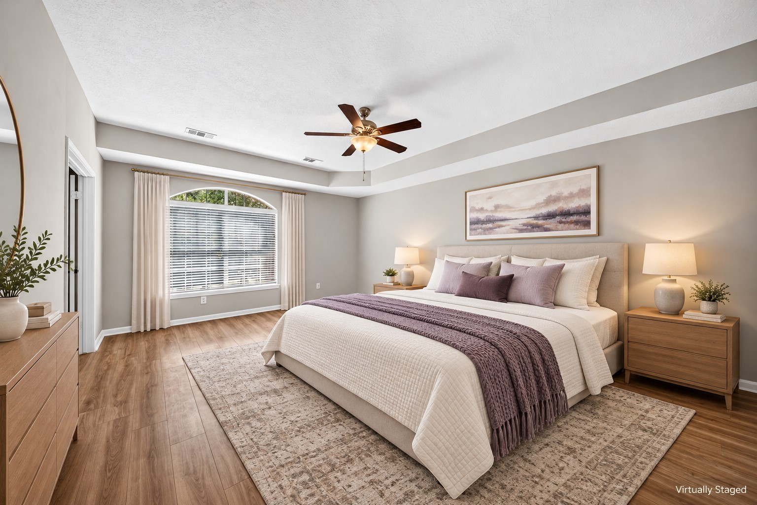 Primary Bedroom  Alternate View: Beautiful arched window welcomes abundant natural light into the spacious primary suite, complemented by a tray ceiling and neutral interior finishes.