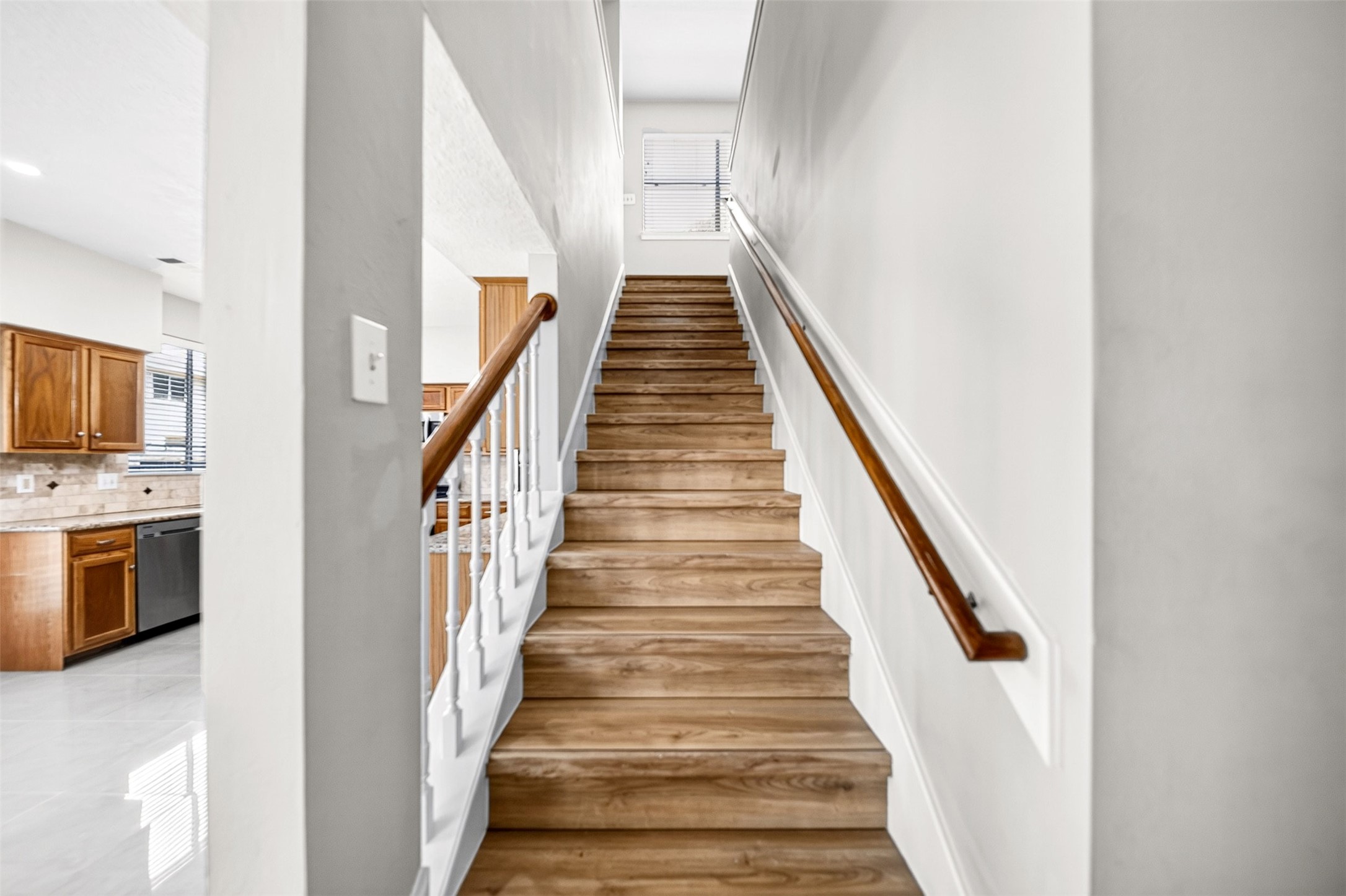 Staircase  Updated Flooring

Beautiful staircase featuring wood-look flooring, crisp white balusters and warm wood handrails, creating an inviting transition to the home's spacious second level.