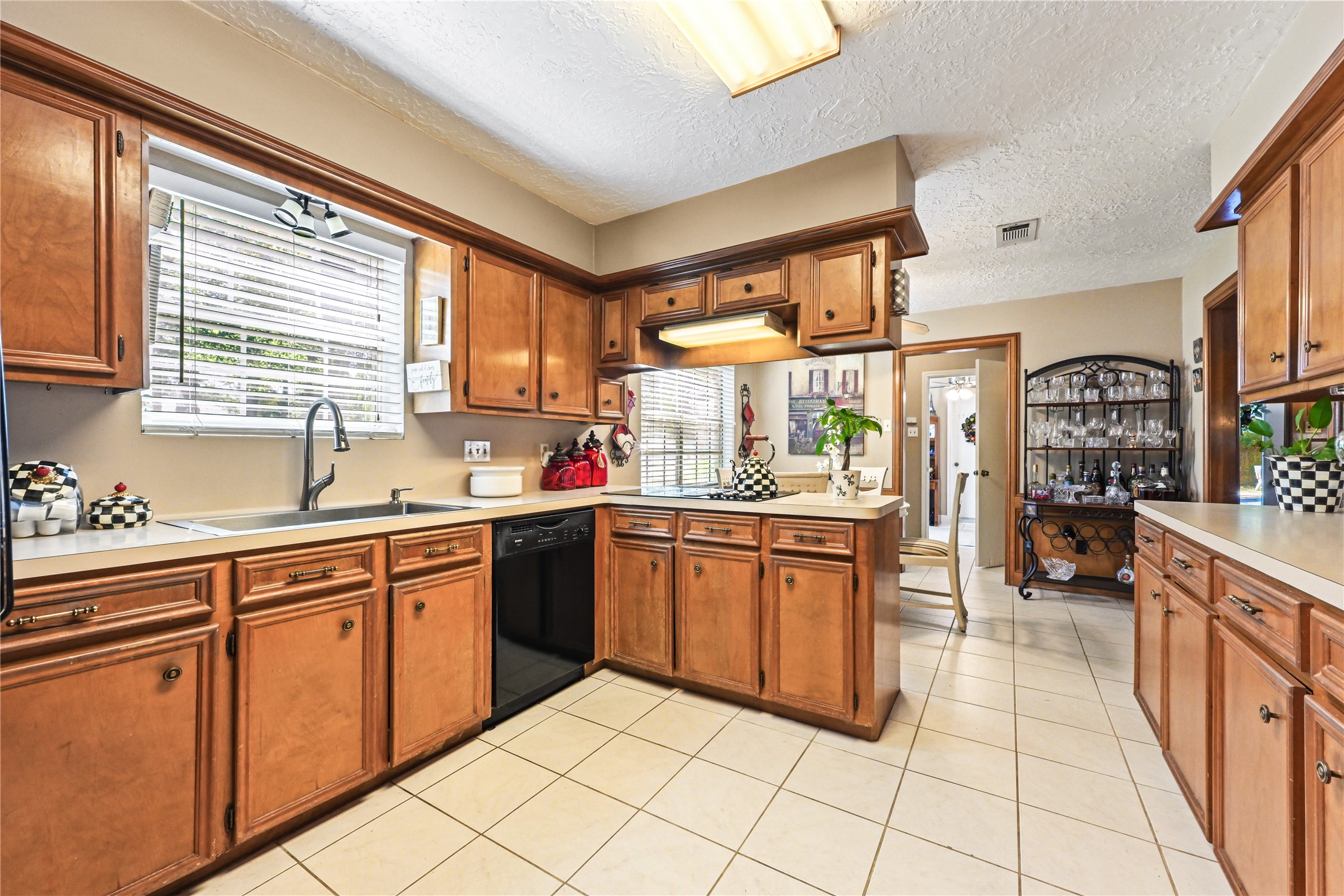 Spacious kitchen with warm wood cabinetry, ample counter space, and a cozy breakfast nook, perfect for family gatherings.