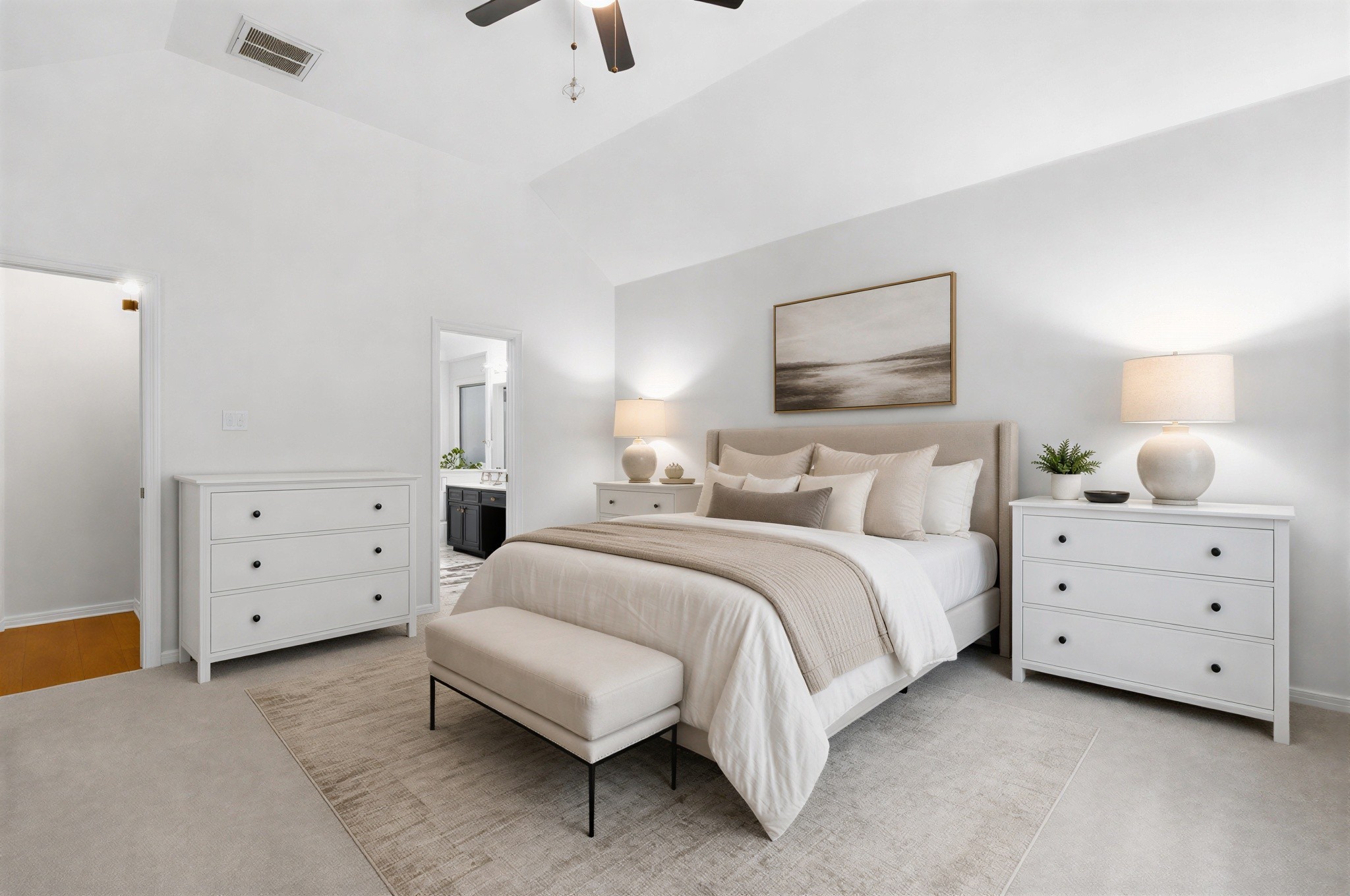 Elegant bedroom with soft neutral tones, featuring a plush bed, matching nightstands, and ample natural light.