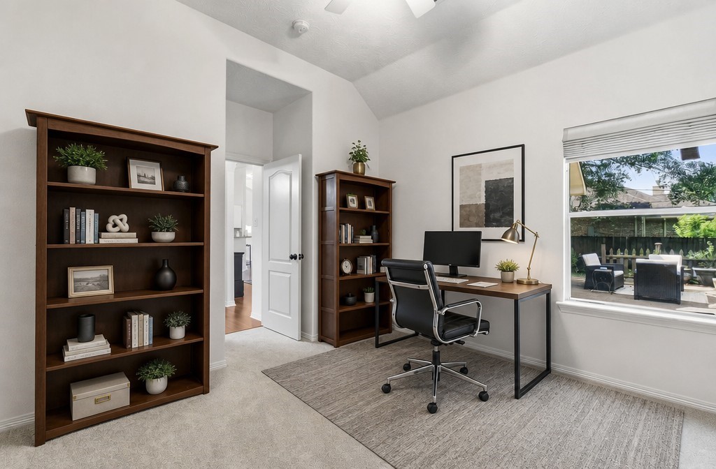 Bright and inviting home office featuring large windows with garden views, ample shelving, and a sleek workspace ideal for productivity.
