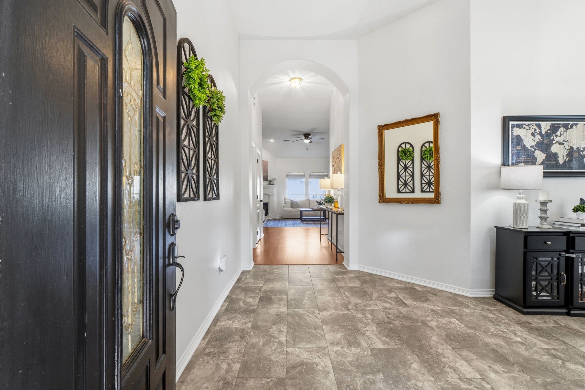 Inviting entryway with elegant tile flooring, high ceilings, and tasteful decor leading to an open, airy living space.