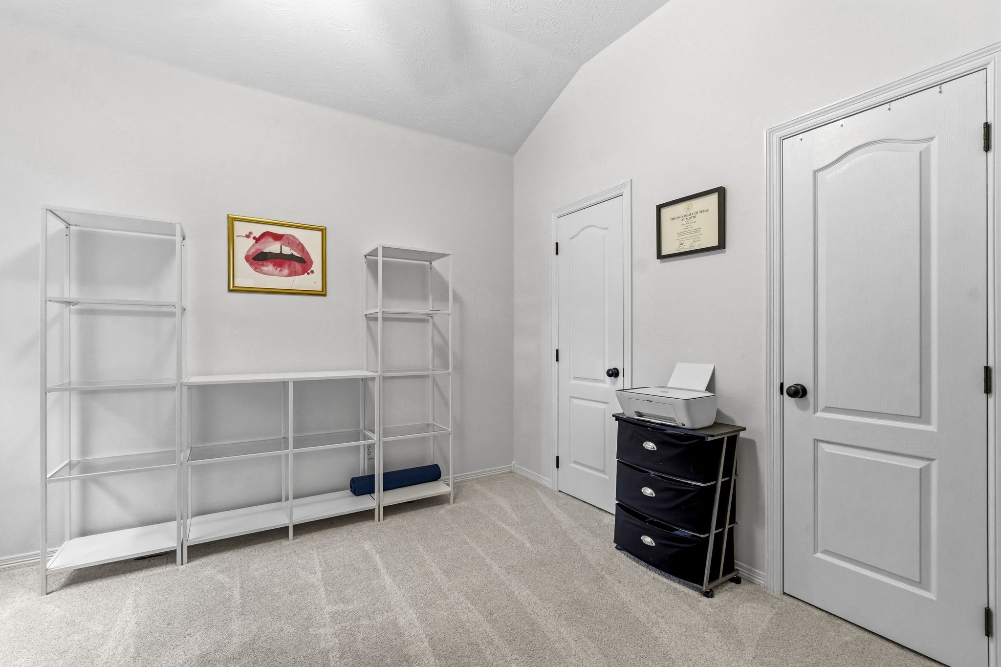Bright, versatile room with ample shelving and storage, perfect for a home office or study.