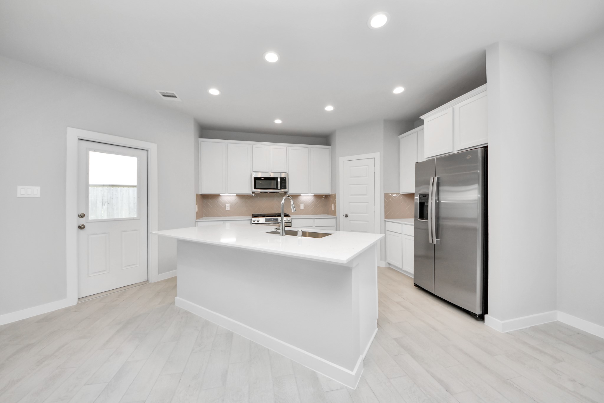 The kitchen is a culinary haven, featuring granite countertops, a tile backsplash, stainless steel appliances, 42 upper cabinets, and undercabinet lighting. Sample photo of completed home with similar floor plan. Actual colors and selections may vary.