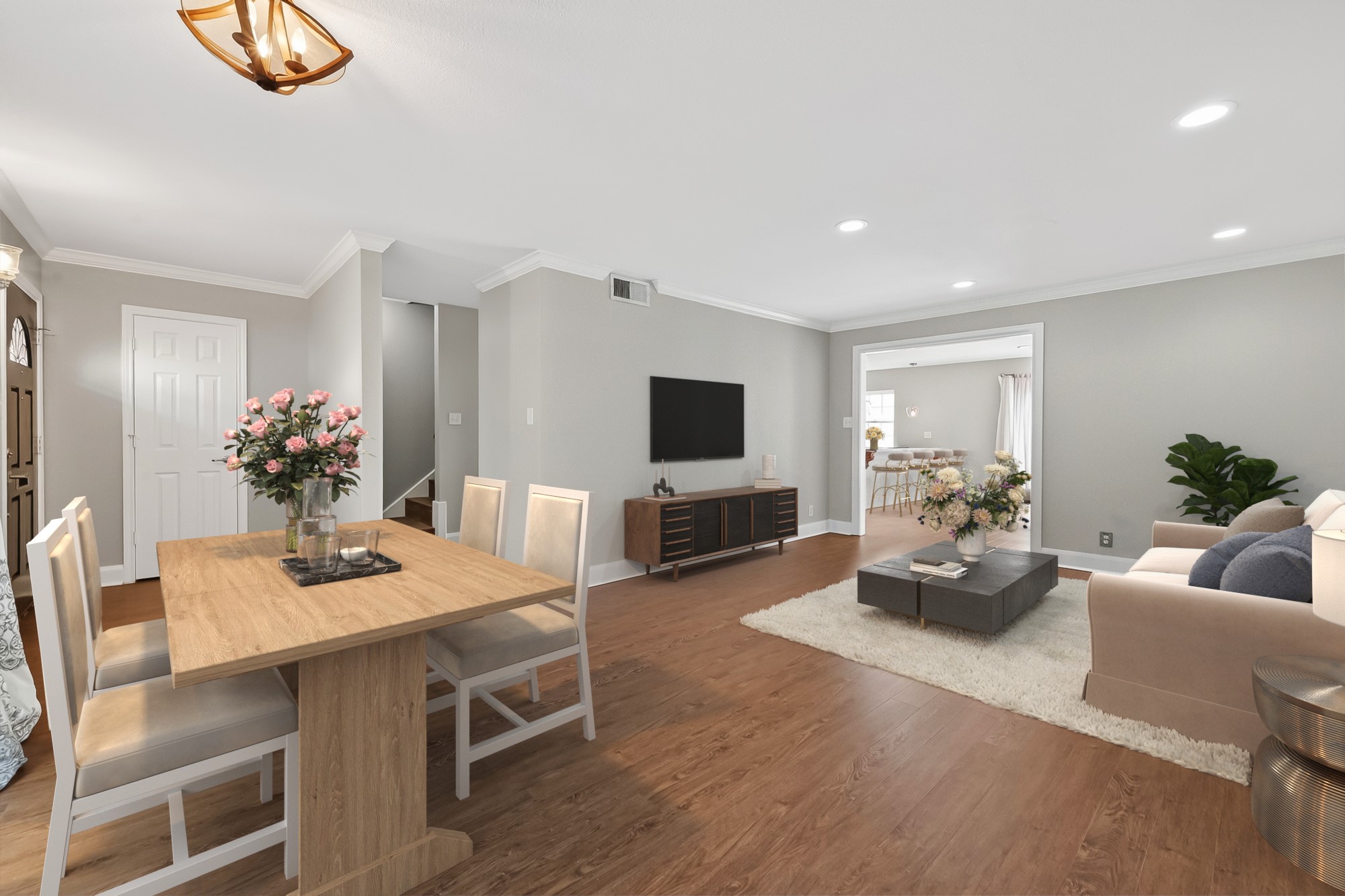 Spacious open-concept living and dining area with luxury vinyl flooring, abundant natural light, and functional flow for entertaining.