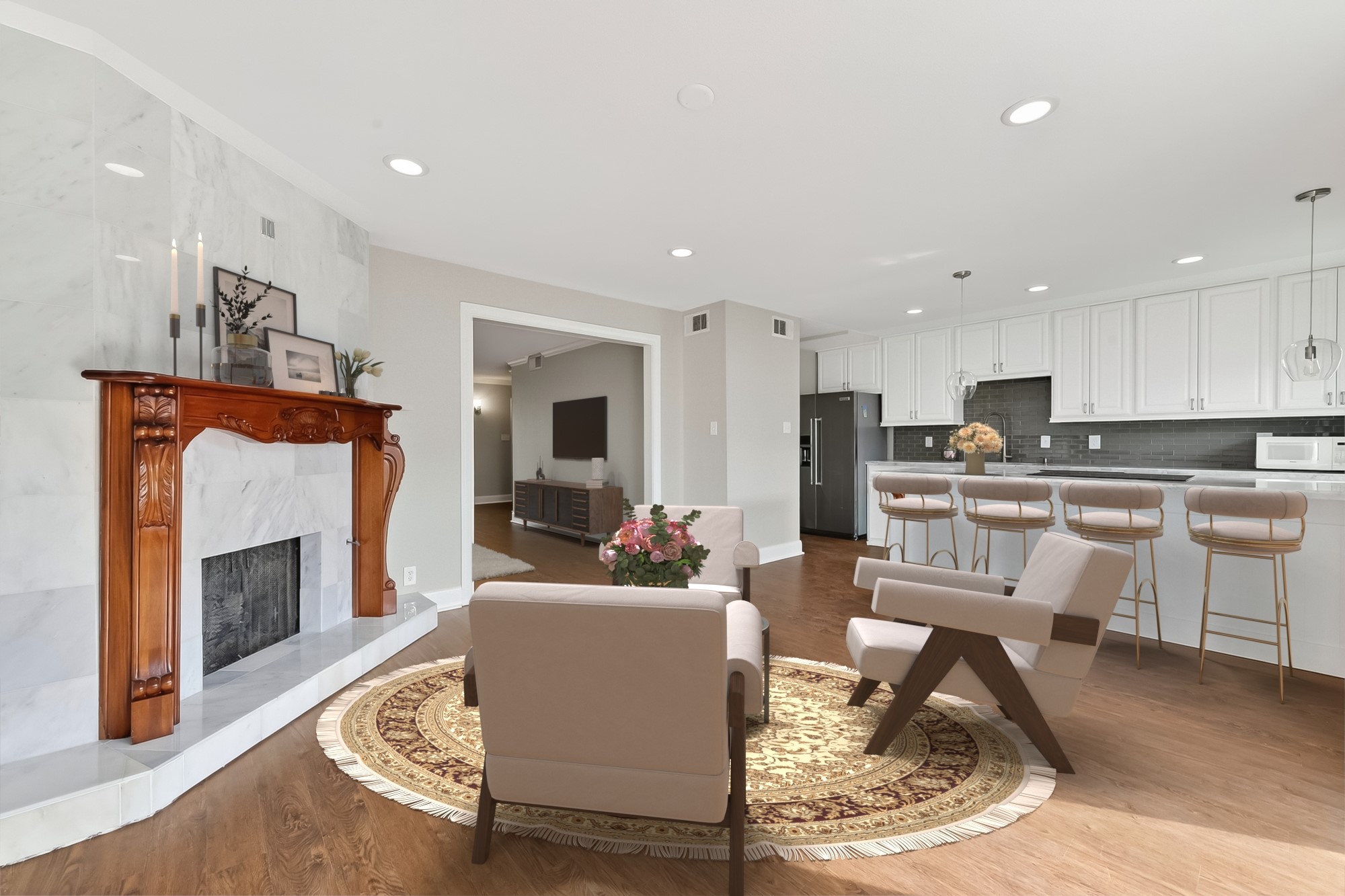 Cozy secondary living area with custom marble fireplace, mantle, and easy connection to the kitchen and patio spaces.