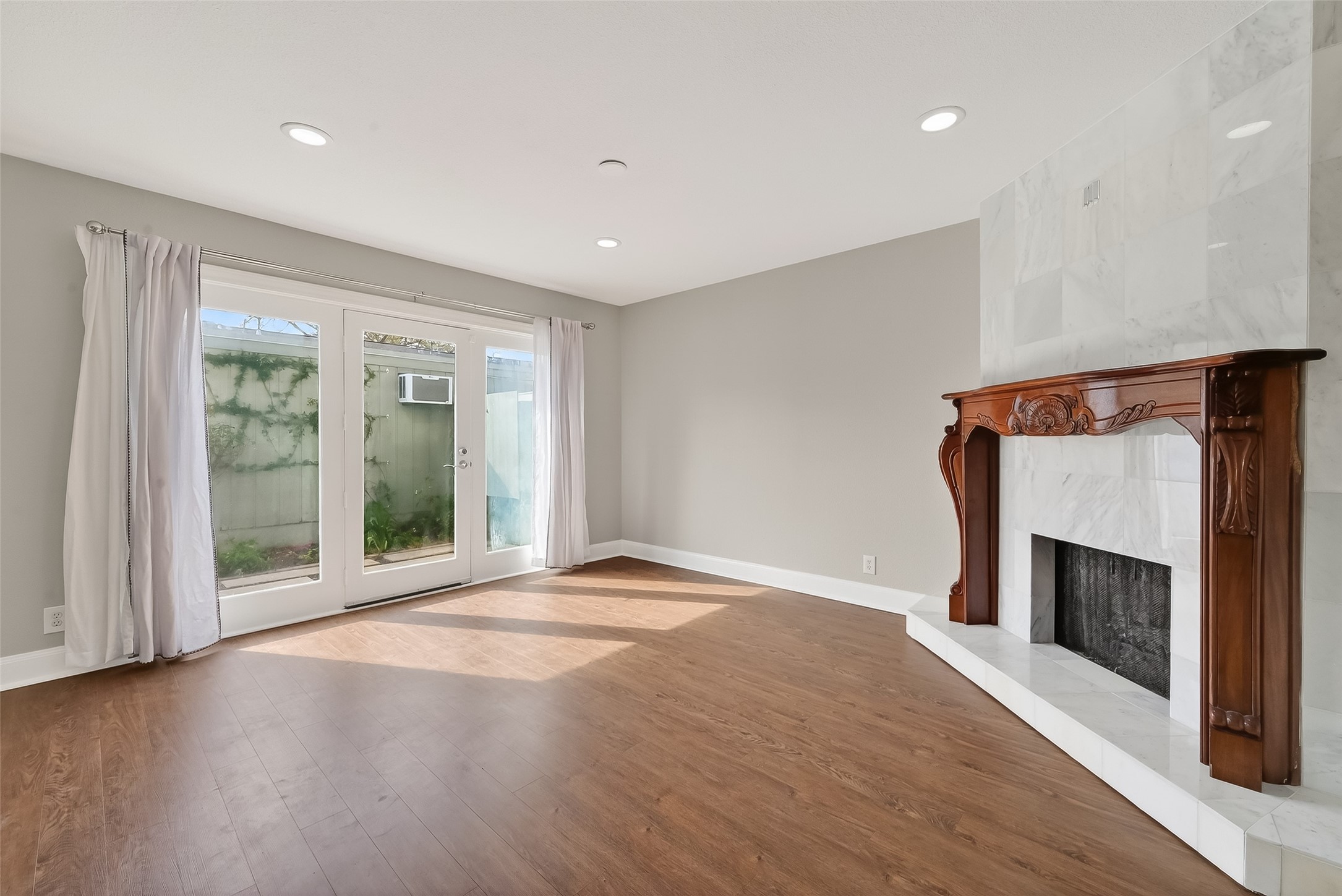 Inviting sitting room with elegant marble fireplace and comfortable open layout perfect for relaxing or entertaining guests.