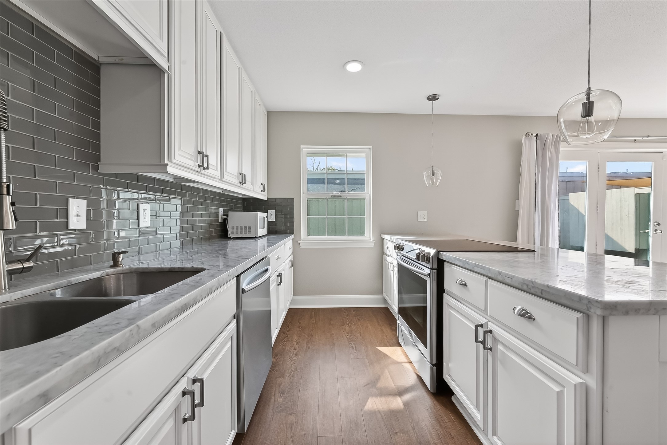 Updated kitchen with Carrera marble countertops, stainless steel appliances, slow-close cabinetry, and modern finishes.