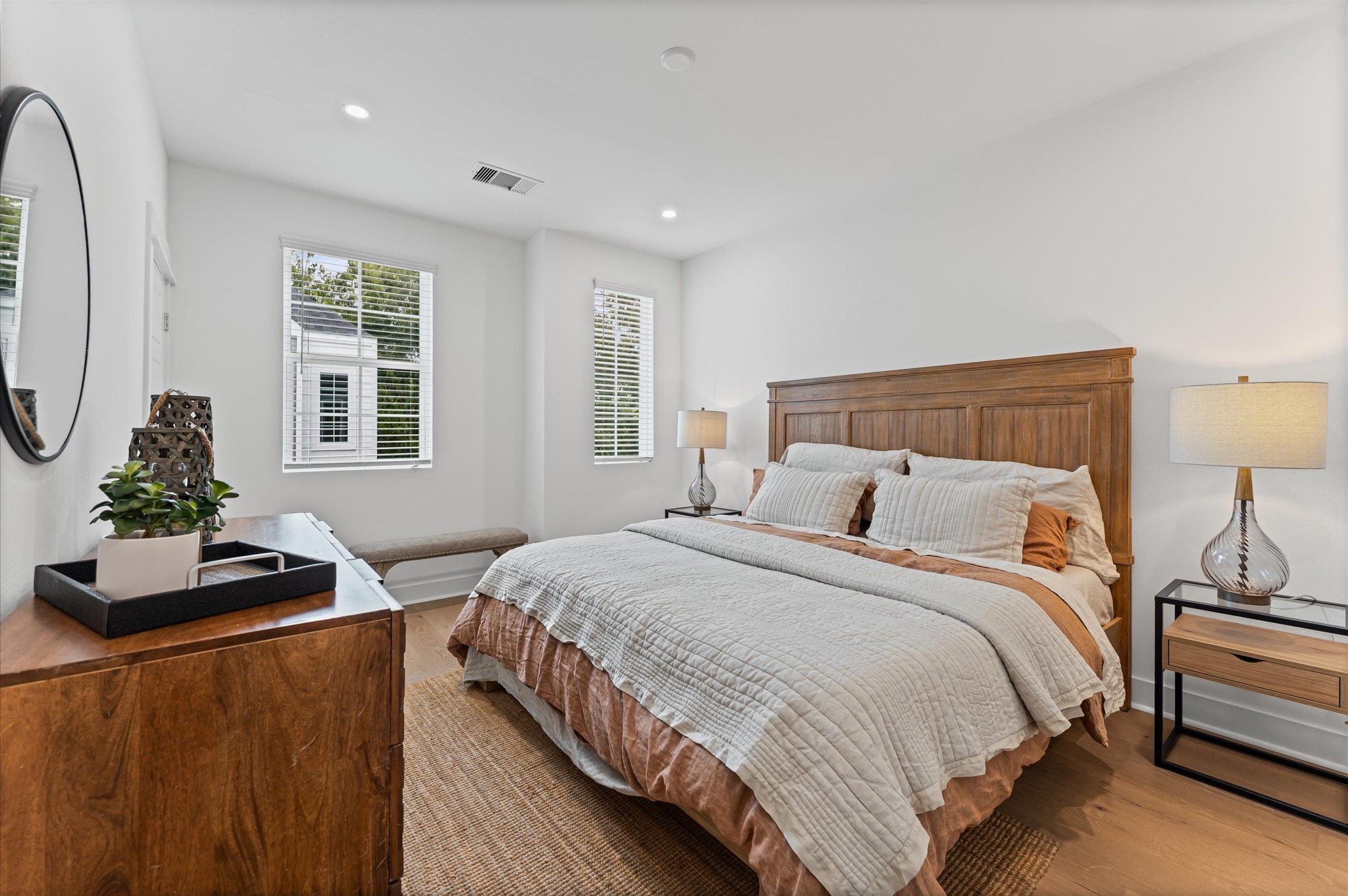 This spacious second-floor primary bedroom exudes modern elegance with its sleek engineered wood flooring that adds warmth and texture underfoot. Soaring high ceilings amplify the sense of openness, allowing natural light to cascade in and highlight the rooms architectural charm. Whether styled with minimalist furnishings or layered with cozy accents, the space offers a serene retreat elevated by its refined finishes and elevated vantage point.