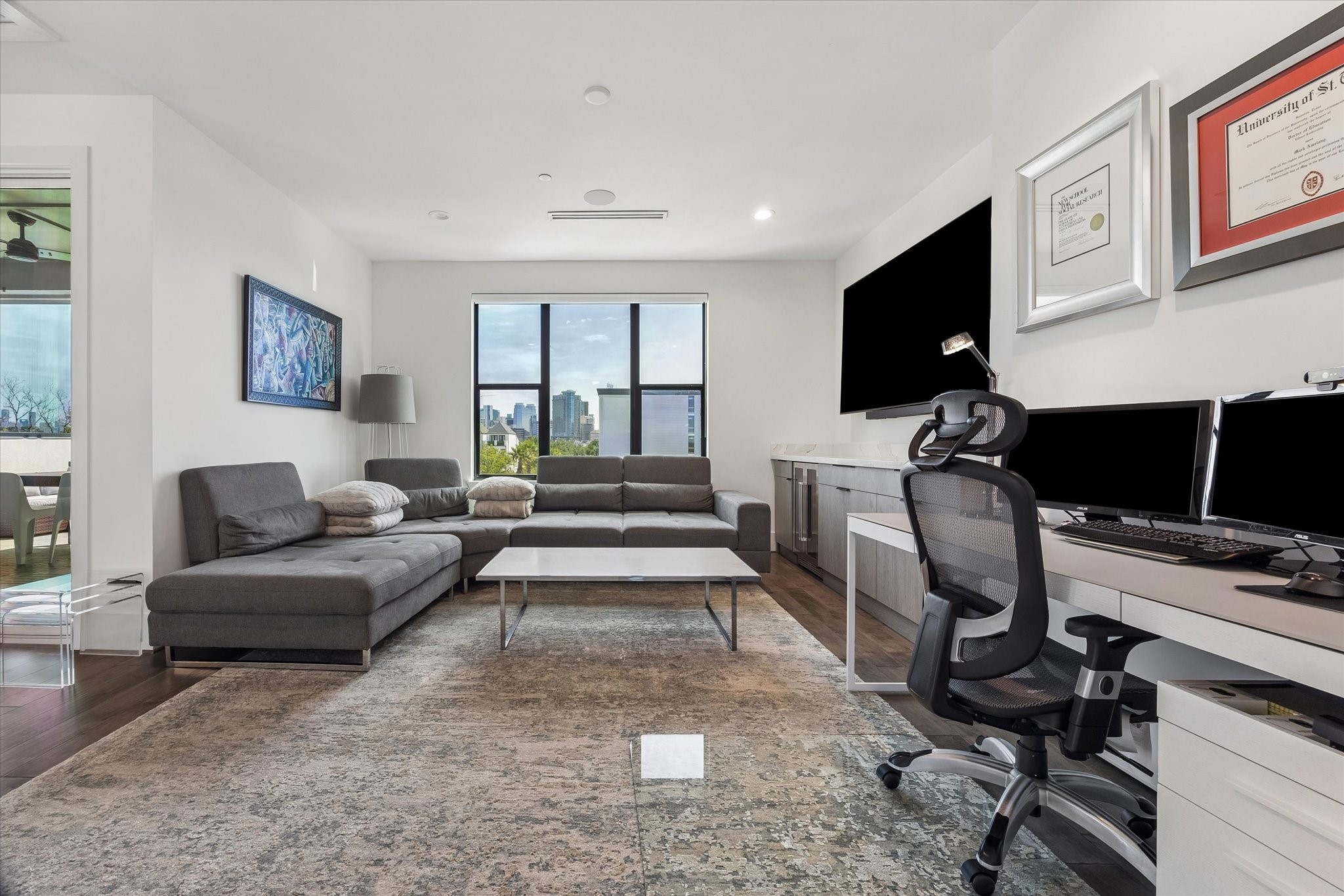 Step into your ultimate media havenfeaturing a sleek entertainment center, cozy sectional seating, and stunning sunset views.