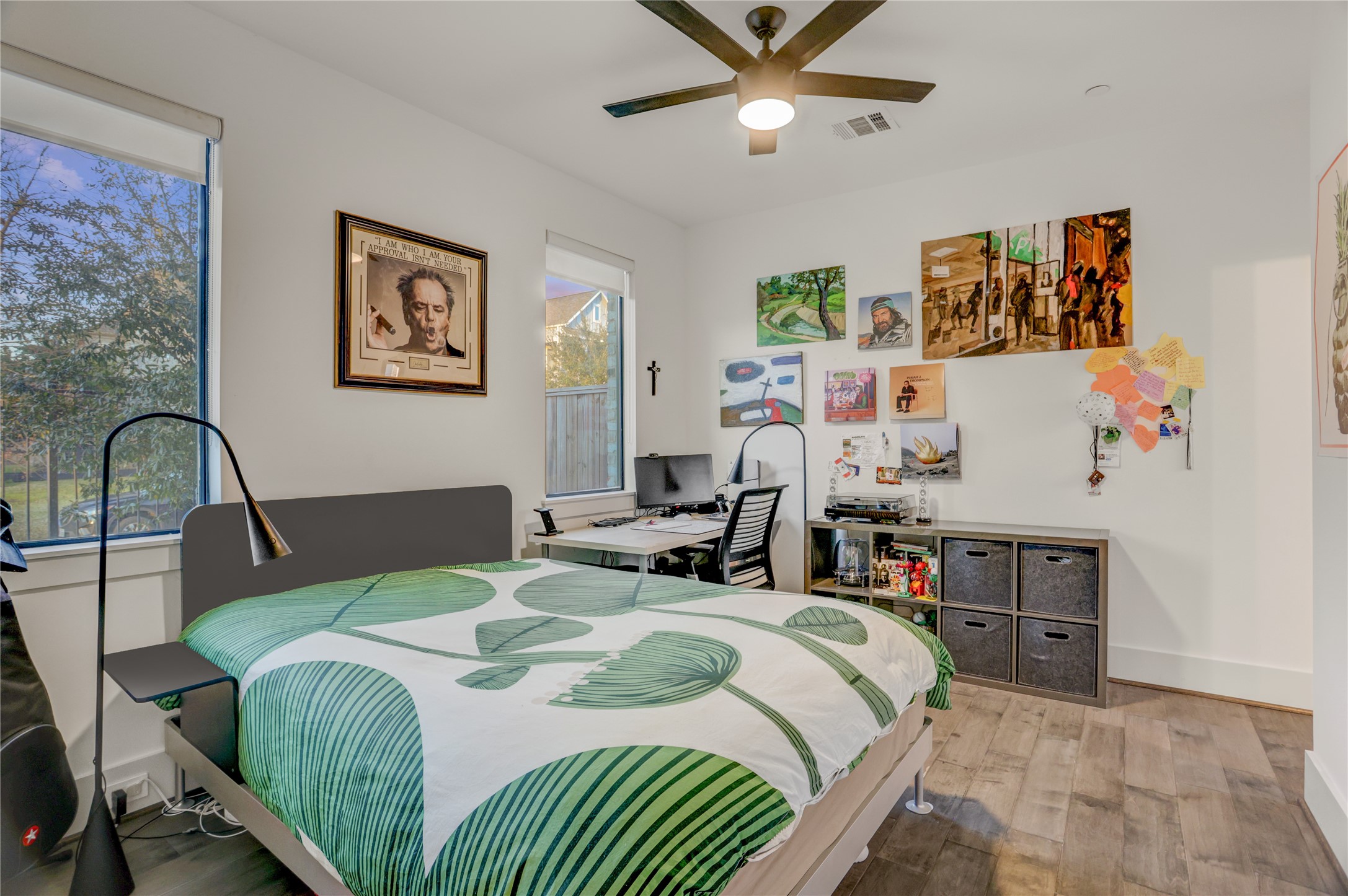 Cozy secondary bedroom with ample natural light, modern ceiling fan, and versatile space for work or relaxation.