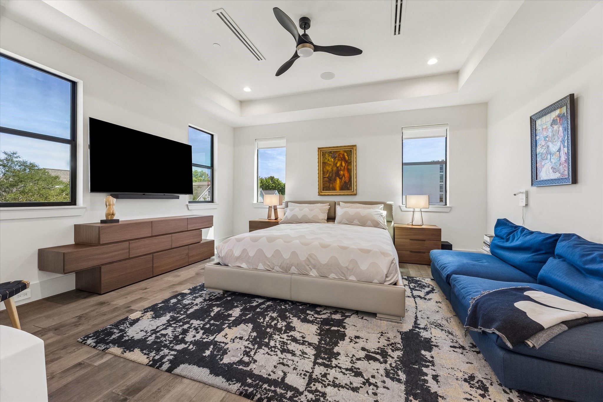 Serene primary bedroom featuring modern decor, ample natural light, and a cozy ambiance for ultimate relaxation.