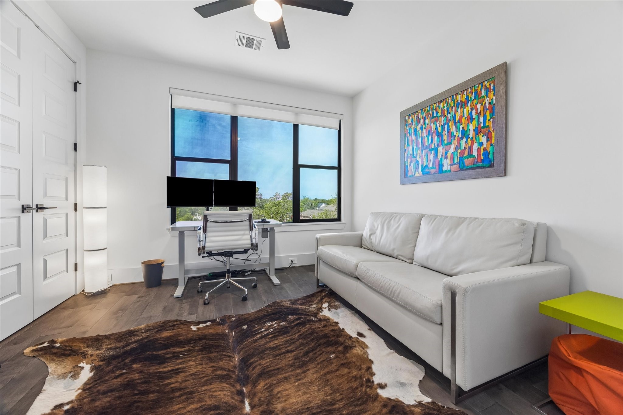 Modern home office/secondary bedroom featuring ample natural light with a serene view.