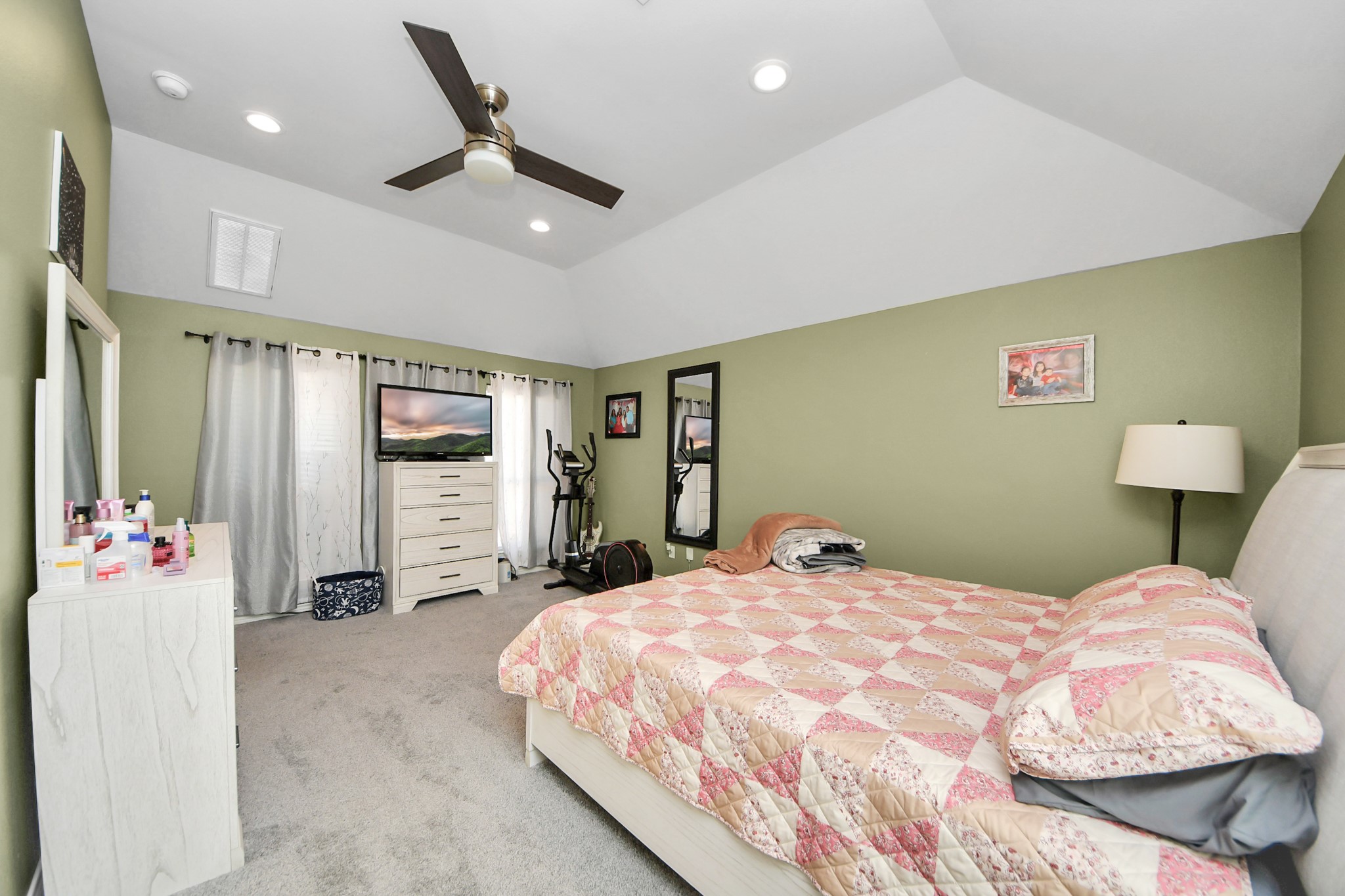 Another primary bedroom angle highlights windows and the raised ceiling.