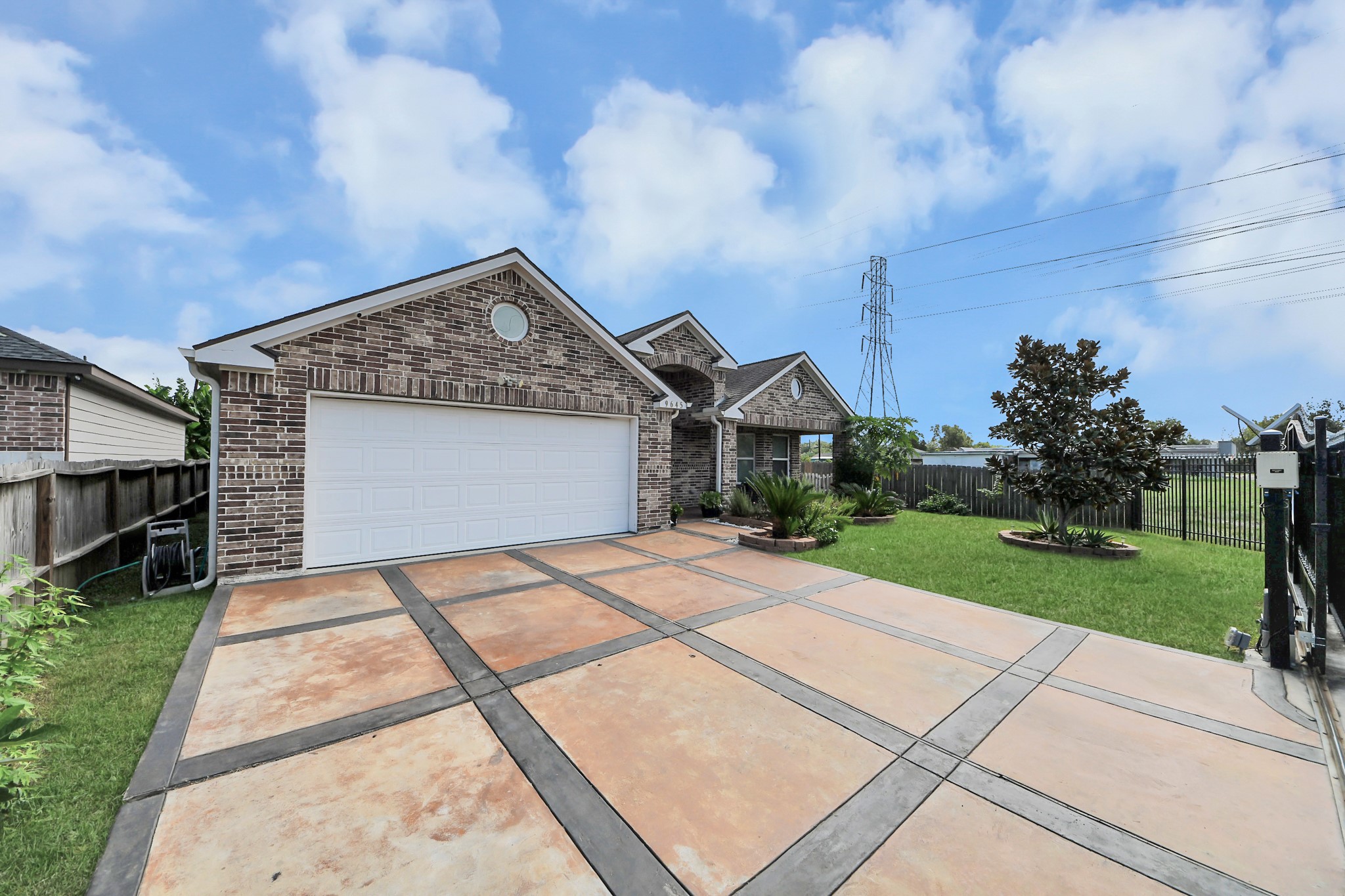 Another view of the driveway, garage, and brick exterior.