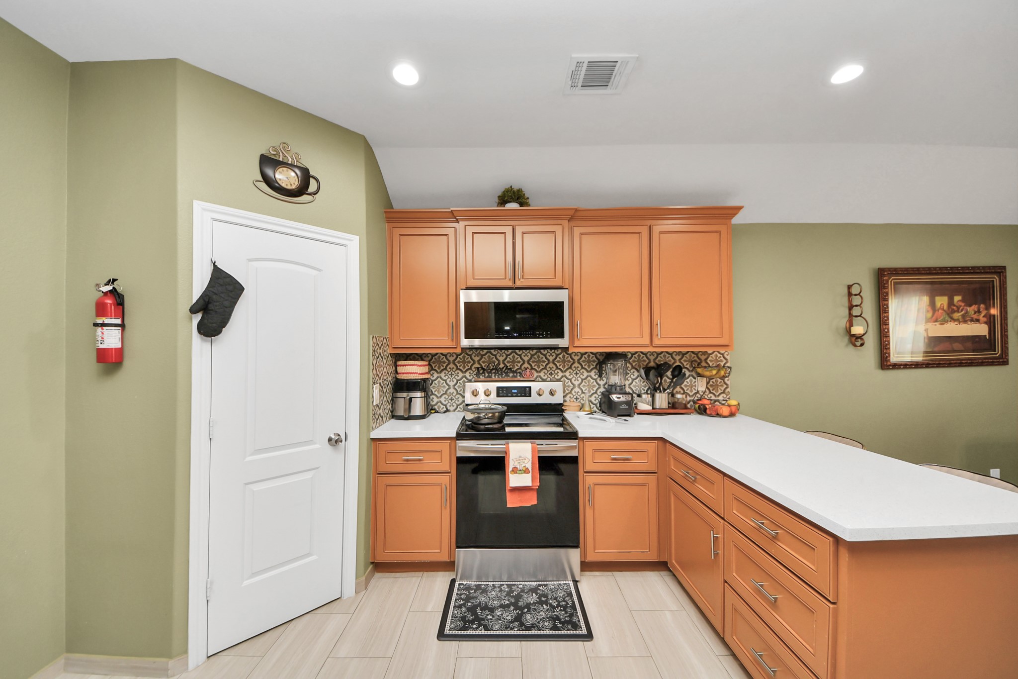 Range and microwave sit among wood cabinets and light counters.