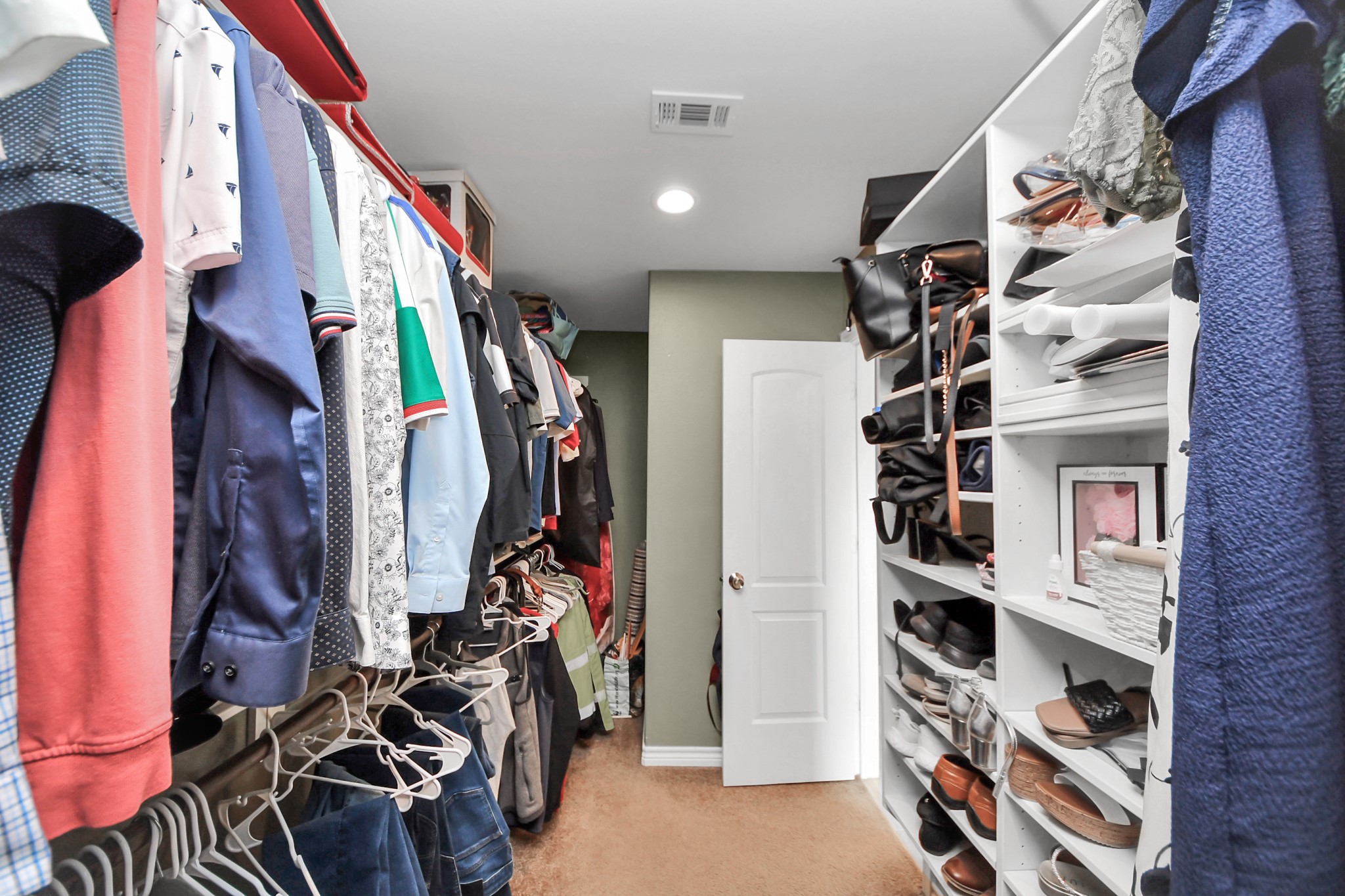 Walk-in closet with hanging space and built-in shelving.